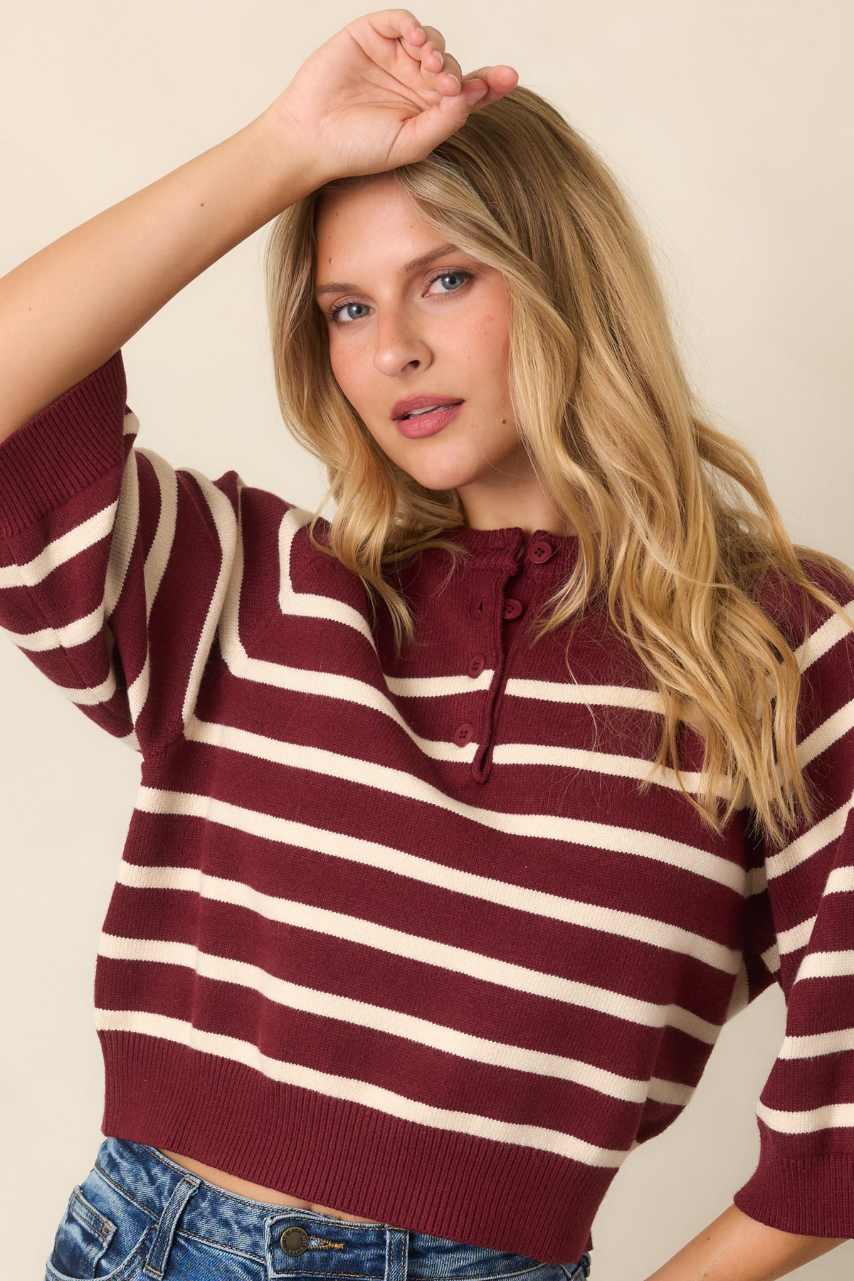 Two-tone knit top showcasing contrasting burgundy and ivory bands with polished ribbed edges.