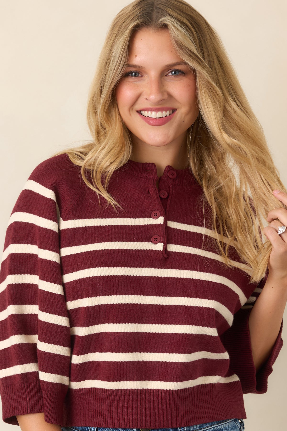 Two-tone knit top showcasing contrasting burgundy and ivory bands with polished ribbed edges.