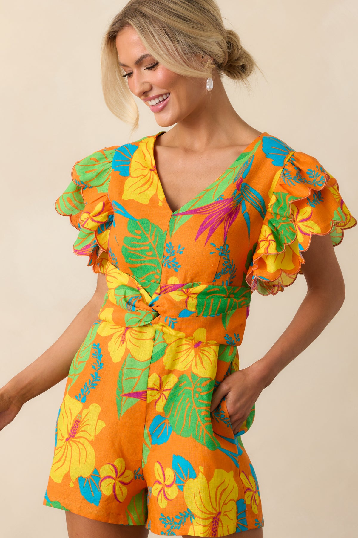 Upper body close-up highlighting the v-neckline and layered flutter sleeves with scalloped edges.