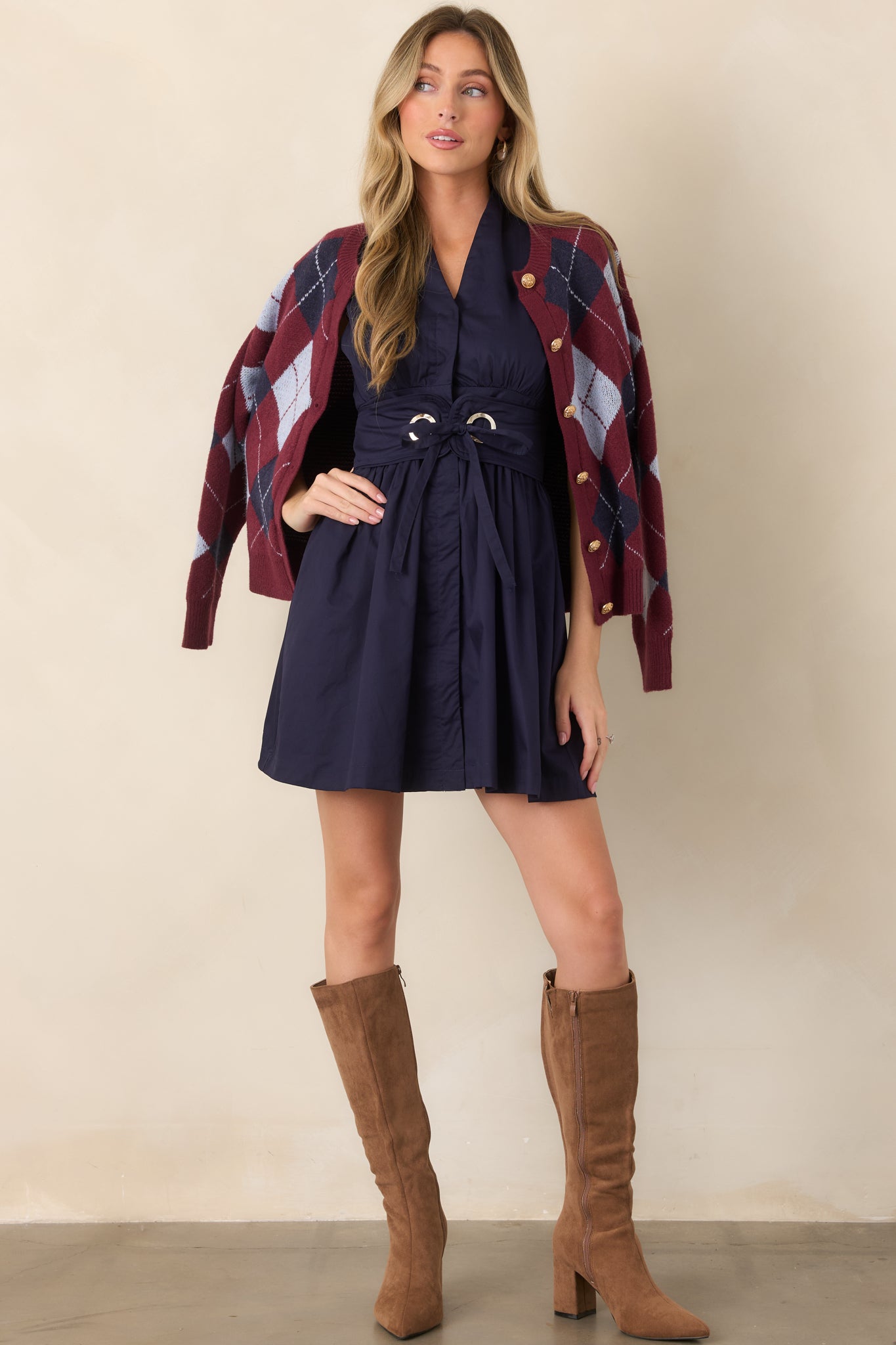 Sleeveless utility-inspired mini dress showcasing its gathered waist, flared skirt, hidden button front, and wide adjustable belt with metal hardware.