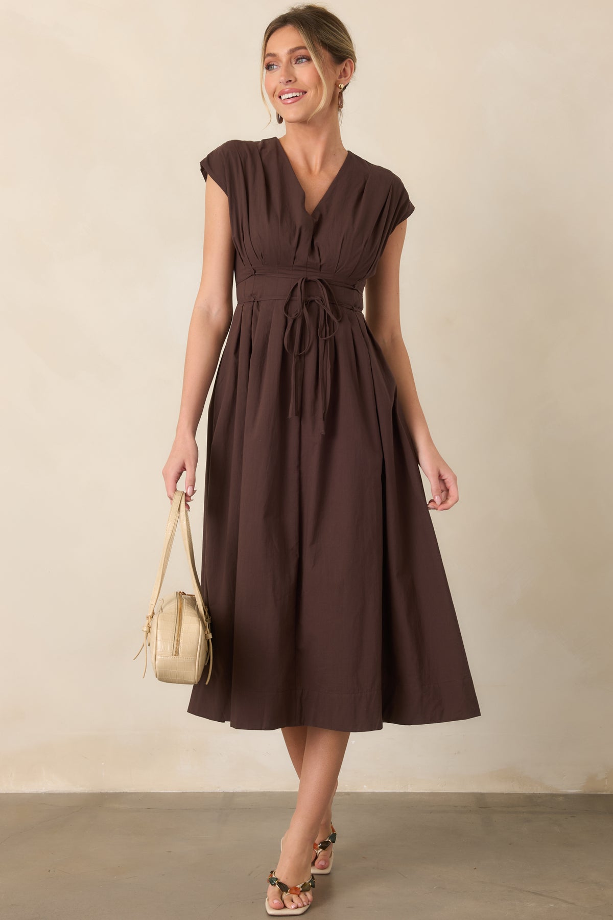 V-neck midi dress with graceful pleating through the bodice, a cinched self-tie waist, and relaxed skirt with side pockets.