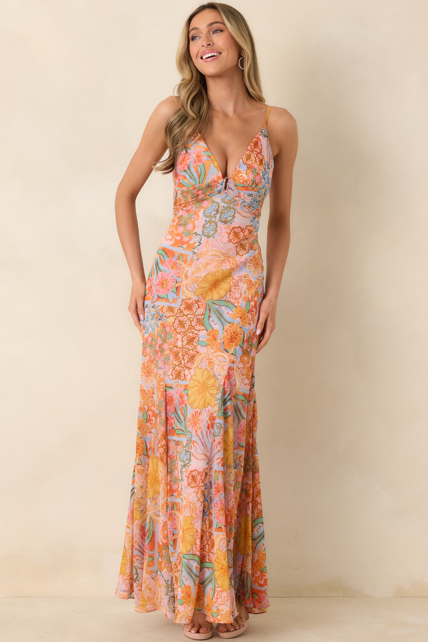 Vibrant multi floral maxi dress featuring adjustable spaghetti straps, center ring at the bodice, smocked back panel, and sweeping hemline movement.
