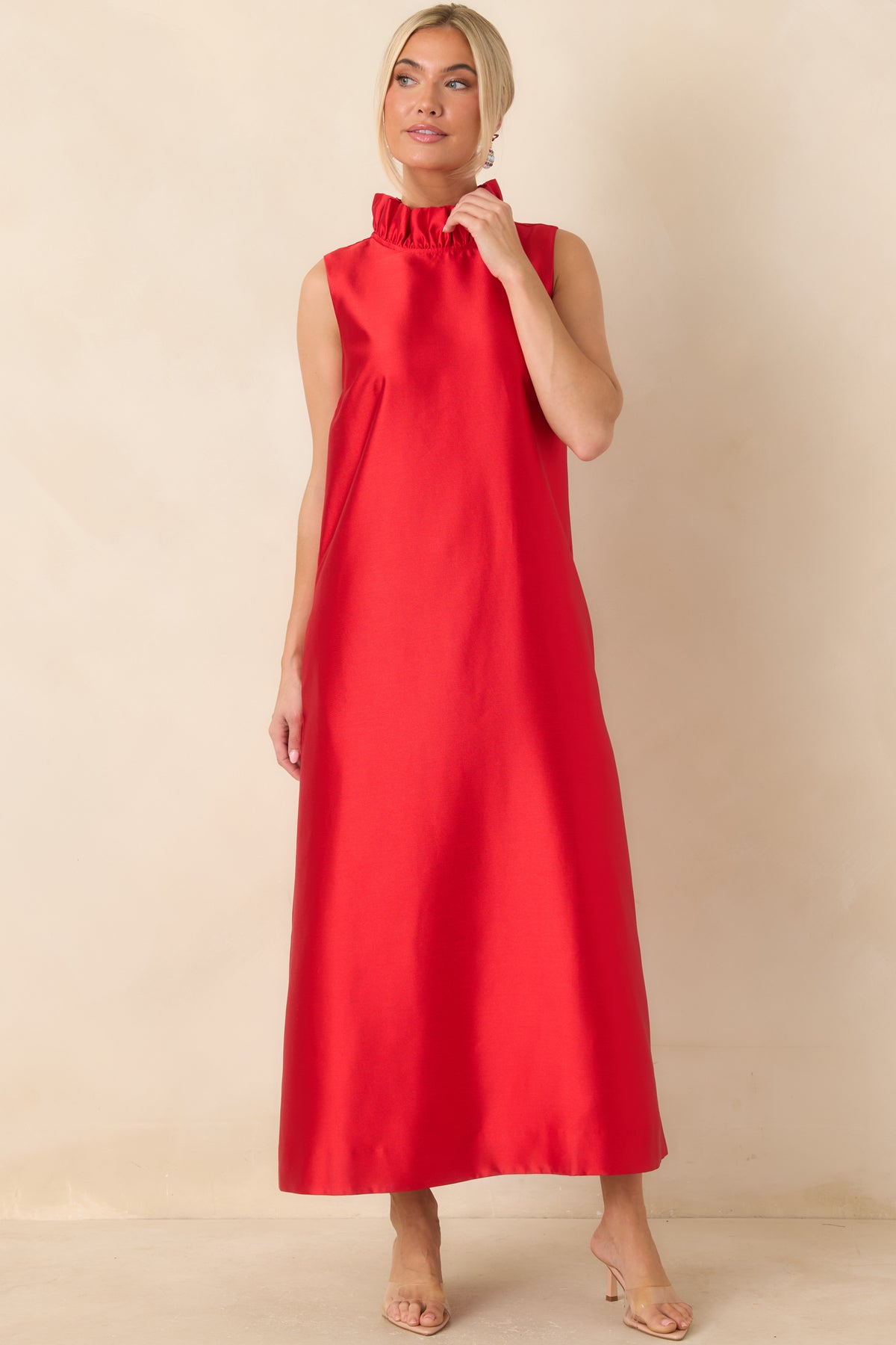 Vibrant red maxi dress with a ruffled high neckline and a smooth silhouette that falls straight from the shoulders.