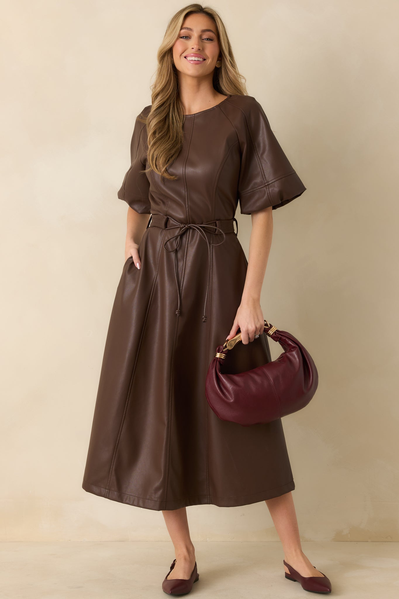 Full-length front view emphasizing the short raglan sleeves, crew neckline, and smooth faux leather texture.
