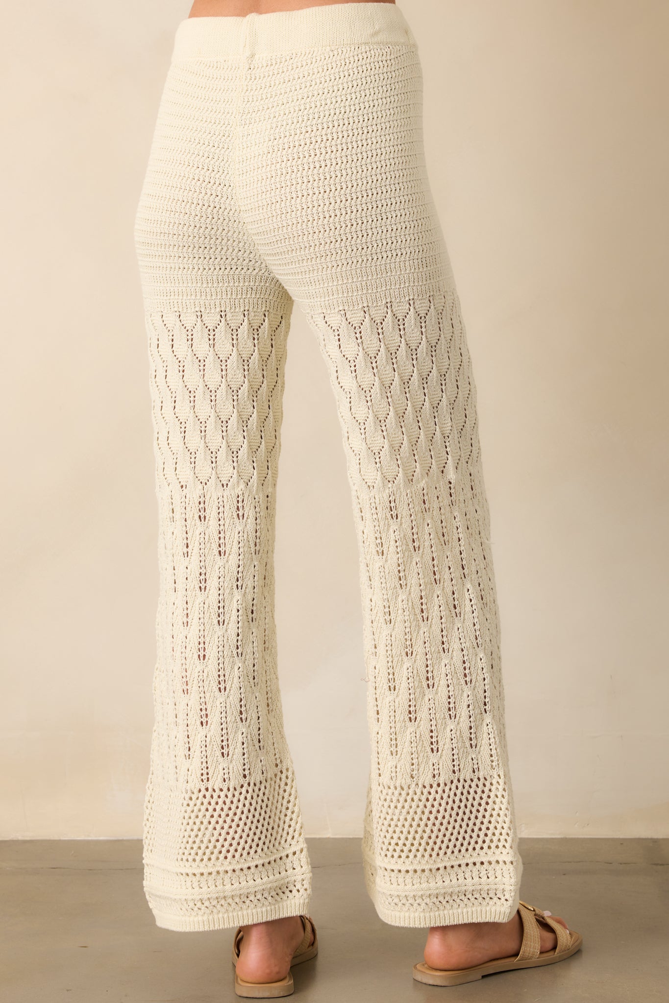 A view from behind of the ivory wide-leg pants, displaying the elastic waistband and continuous crochet pattern.