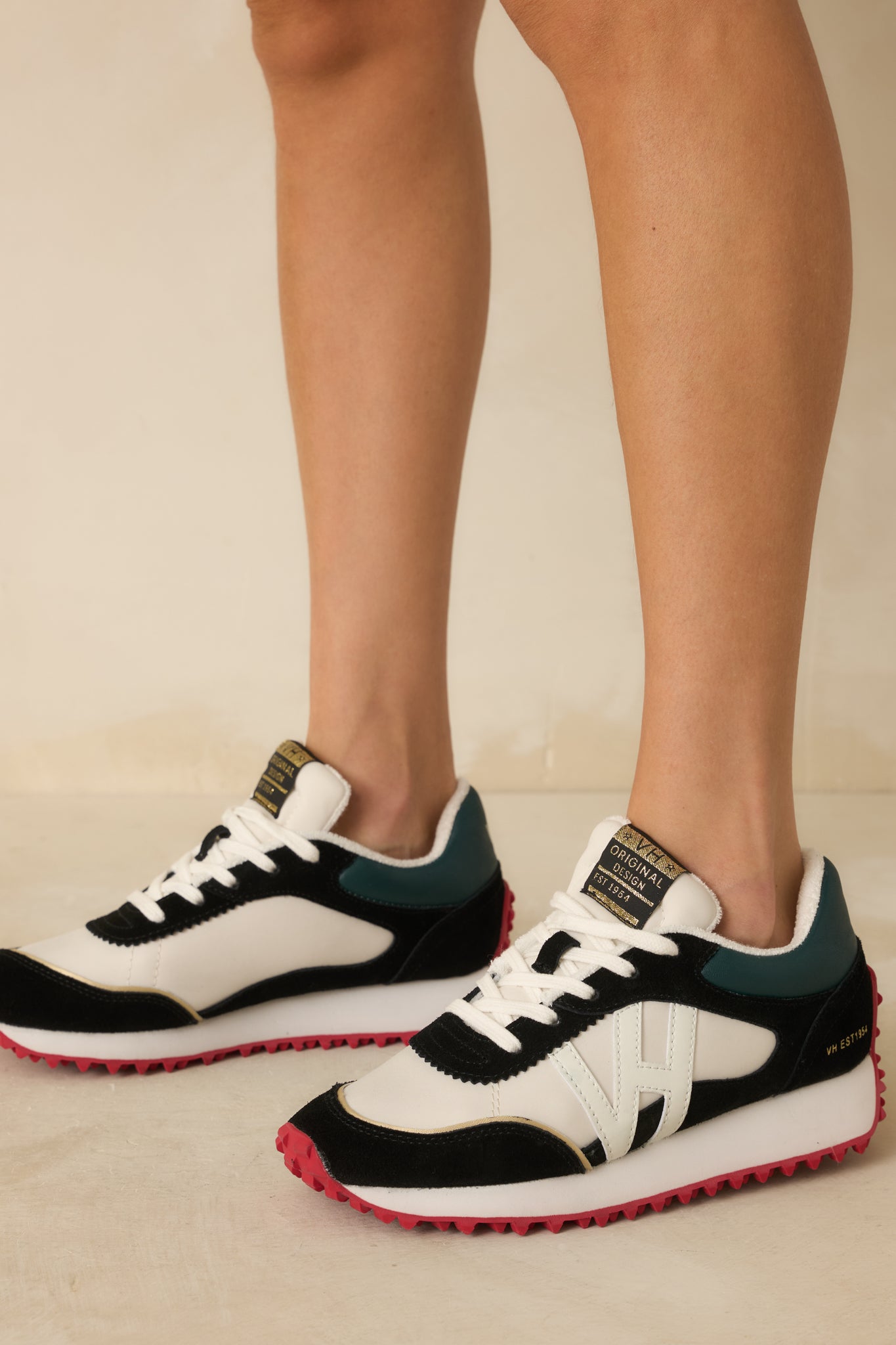 Close view of the side panel showing the black faux suede detail and smooth white leather base