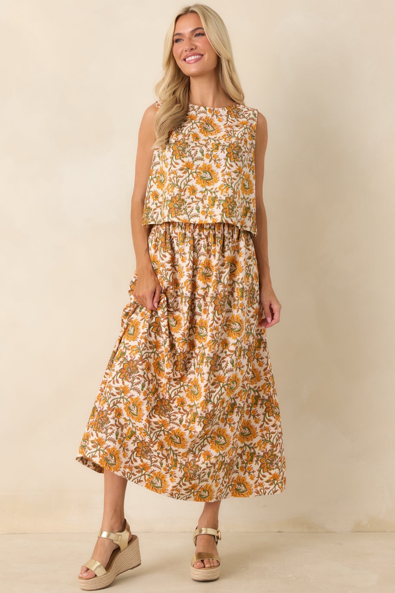 Maxi skirt showcasing a flowing silhouette with a vintage-inspired marigold and olive floral print on an ivory backdrop.
