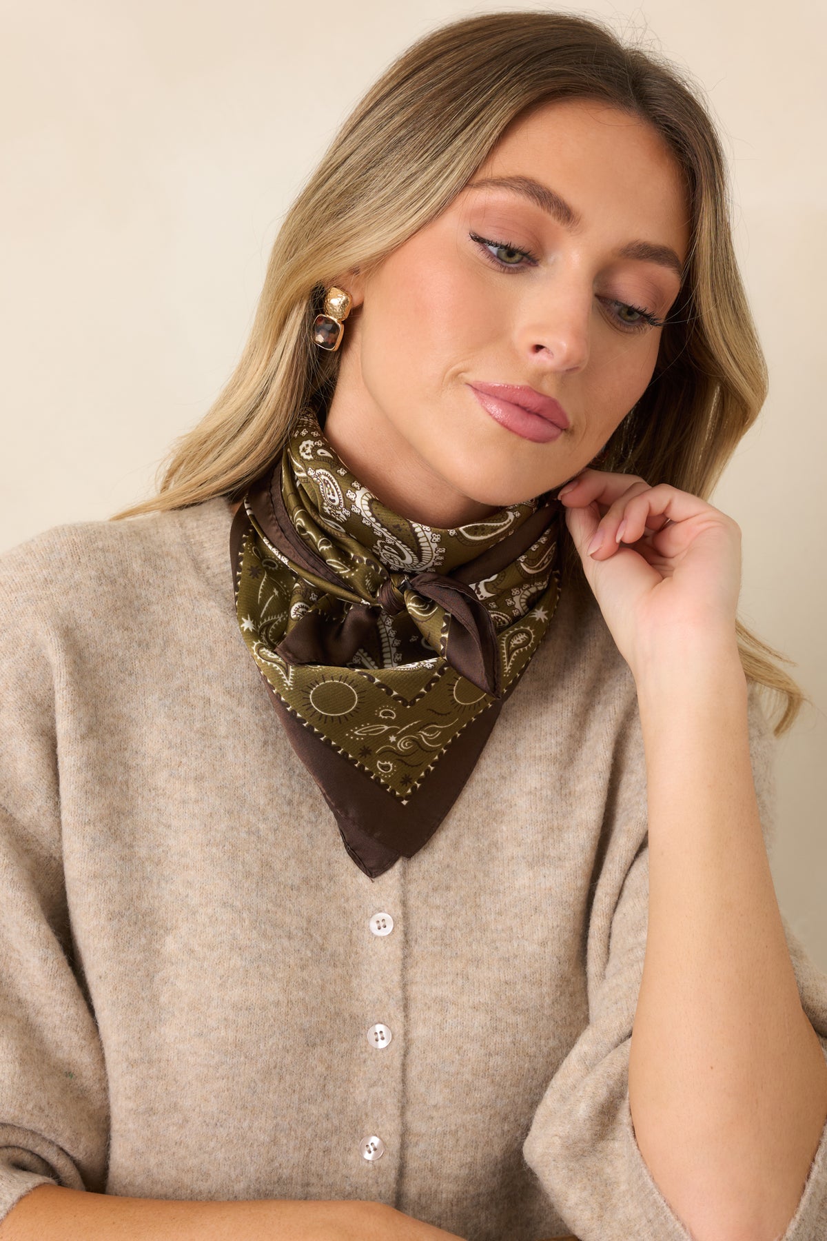 Vintage-inspired paisley scarf showcasing olive green, ivory, and brown tones against a smooth satin finish.