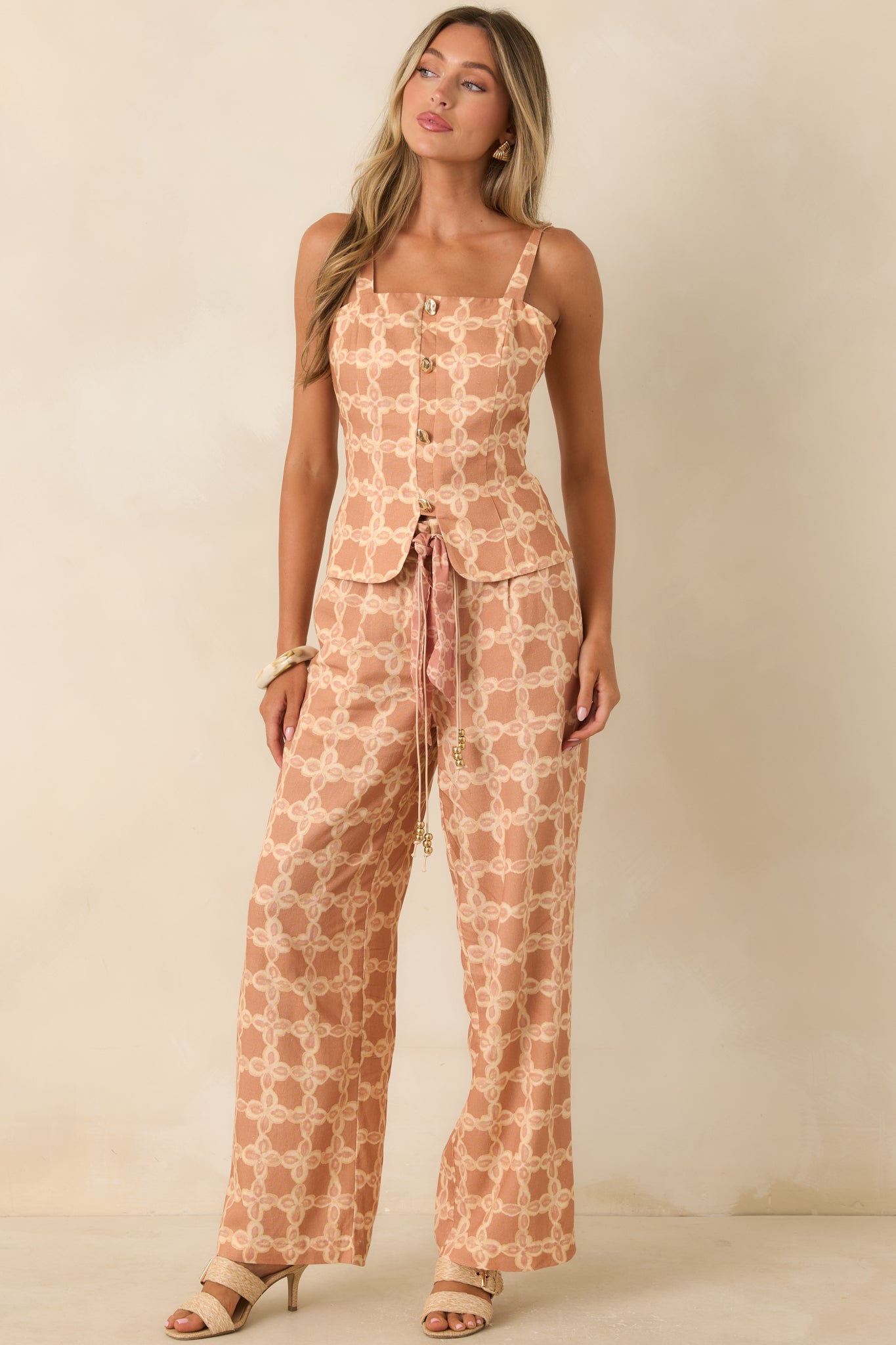 Vintage-inspired wide leg pants with a warm tan and ivory print, functional side pockets, and a flattering high-rise fit.