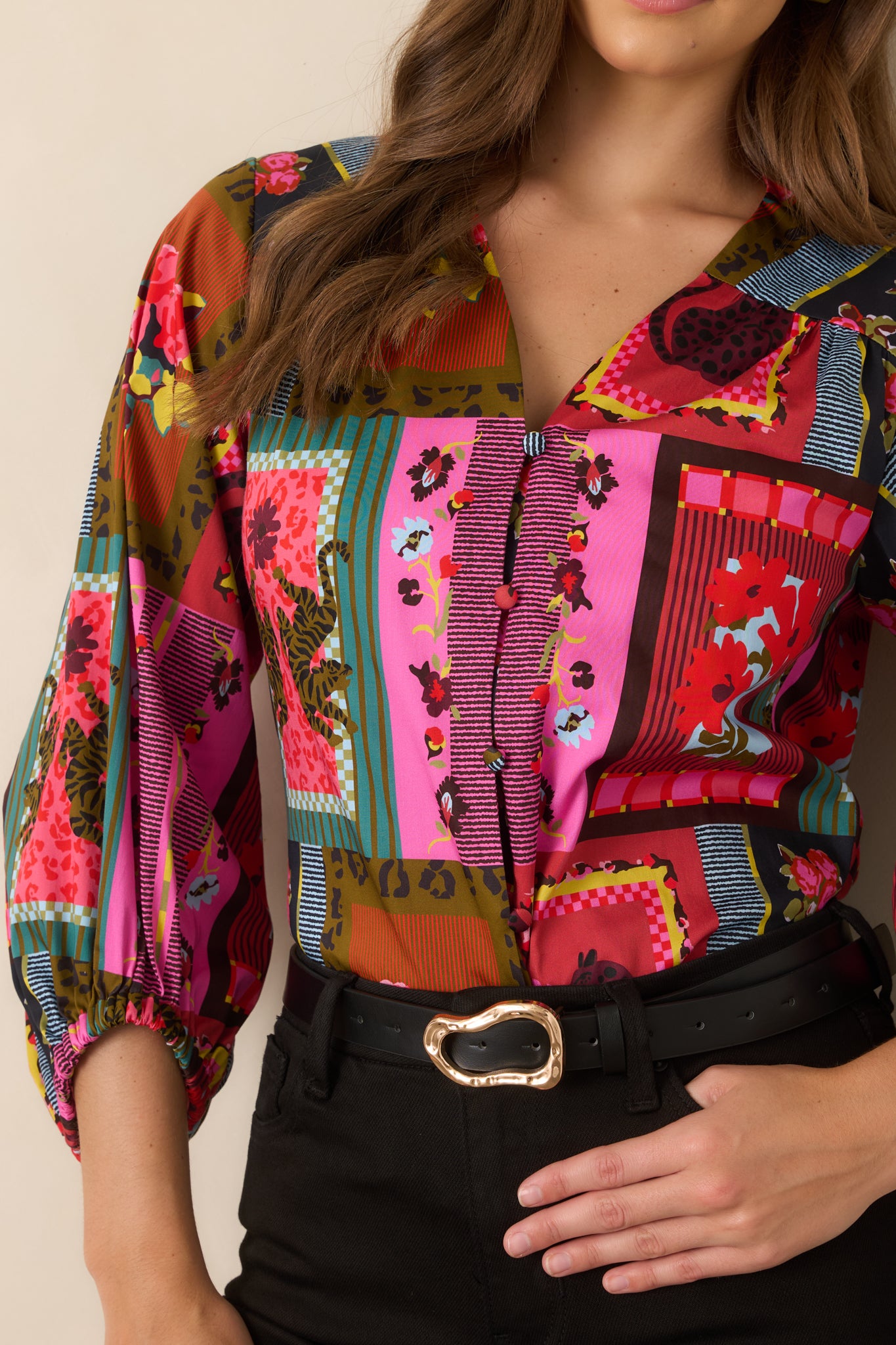 Detailed view of the top highlighting the gathered three-quarter sleeve cuff and vibrant combination of florals, stripes, and framed patterns.
