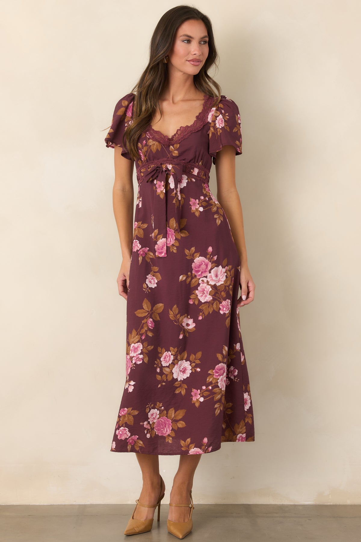 Vintage-style midi dress with a wine background, delicate pink florals, a curved lace-trimmed neckline, and a softly flared skirt.