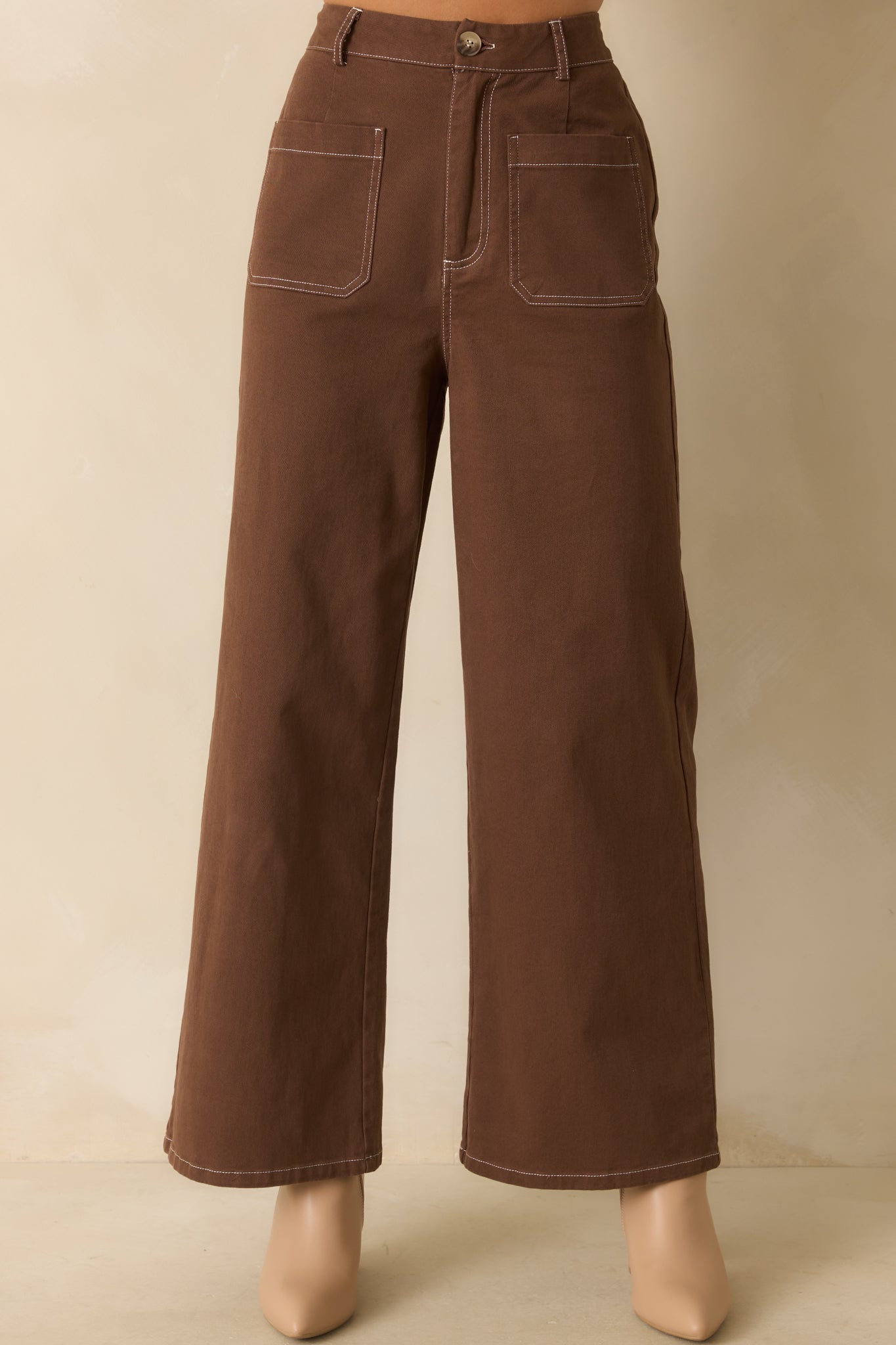Close crop of waist area showing high-rise fit, belt loops, and zip fly with button closure.