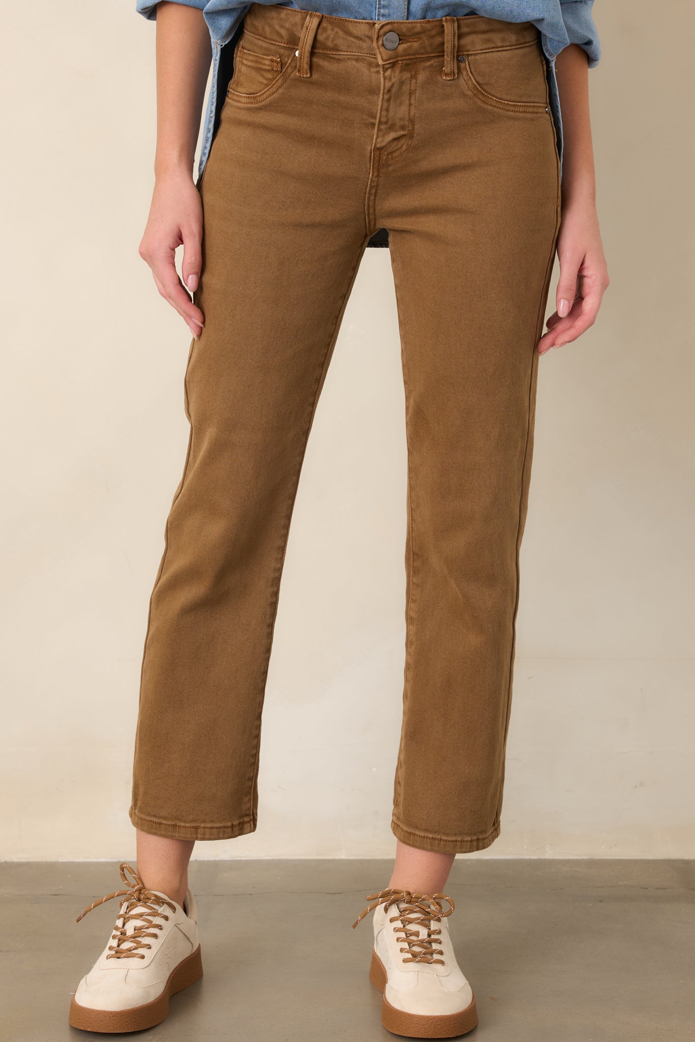 Warm camel brown cropped denim pants showcasing the straight-leg silhouette and clean, structured cotton construction.