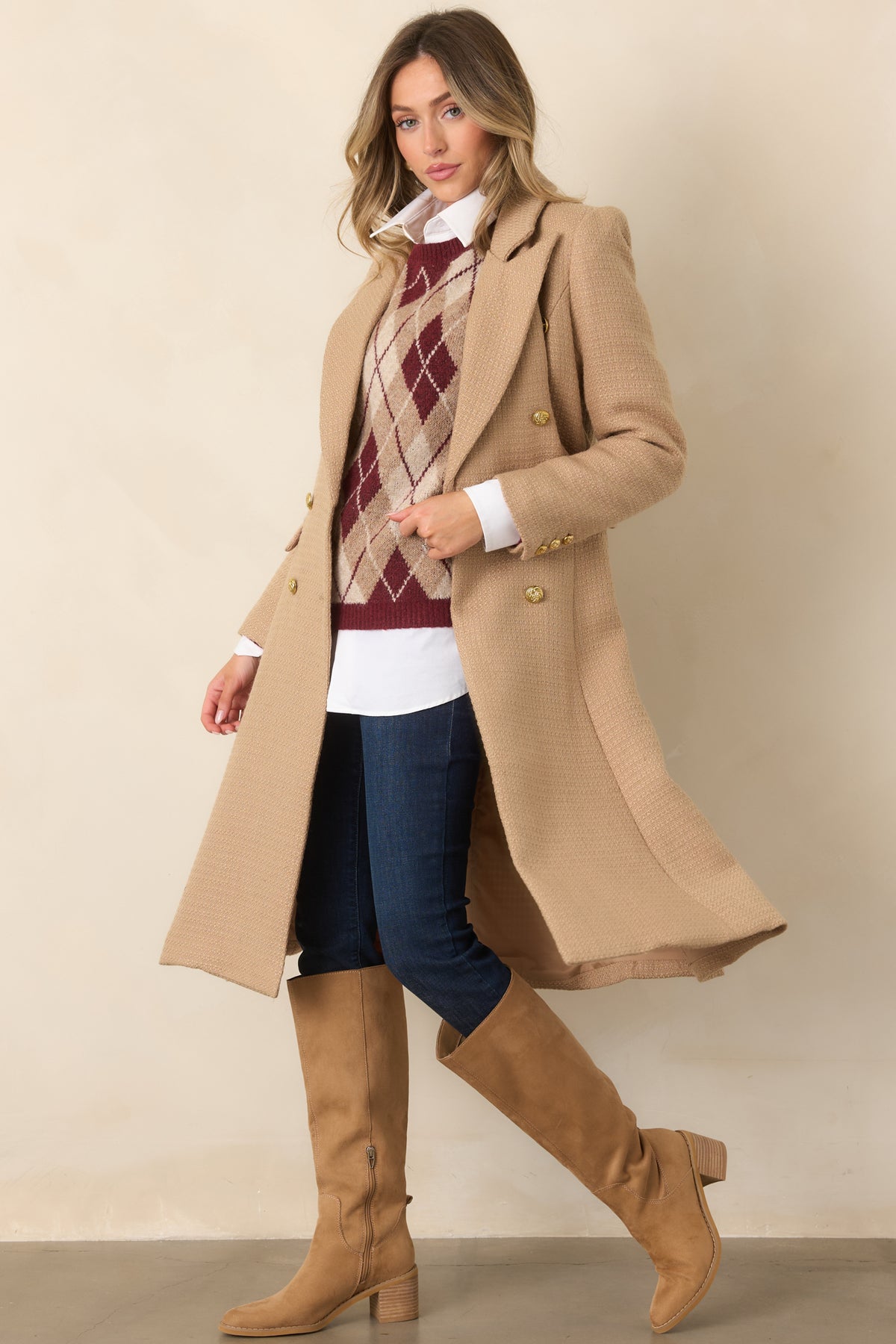 A warm camel tone complements the refined double-breasted front and structured silhouette of this long topcoat.