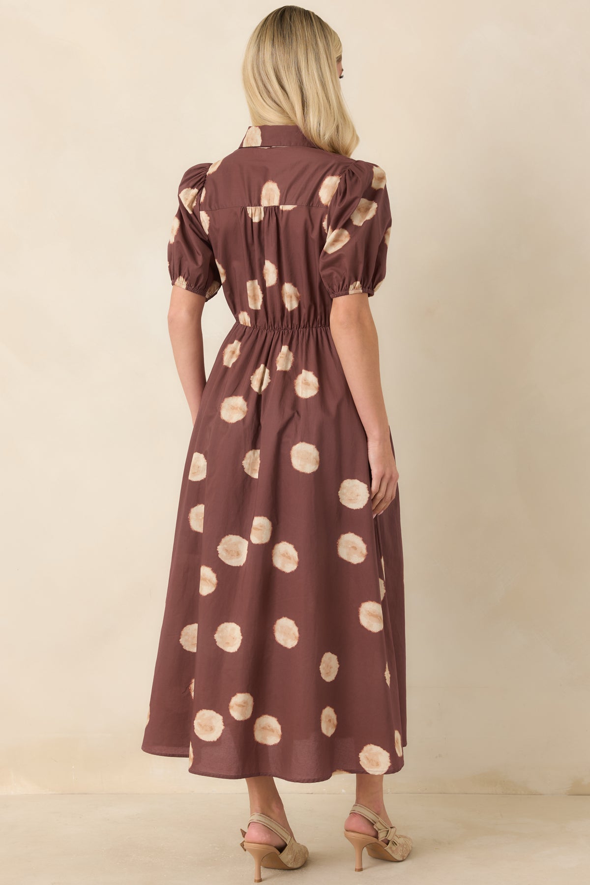 Warm earthy dot-print midi dress showcasing the elastic back waistband and full A-line skirt from the rear.
