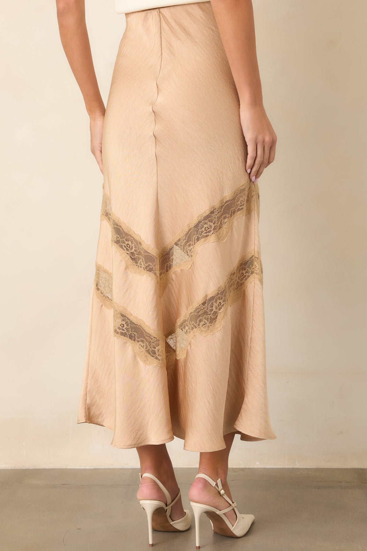 Warm tan skirt showcasing the fitted waist and easy drape through the body from the rear.