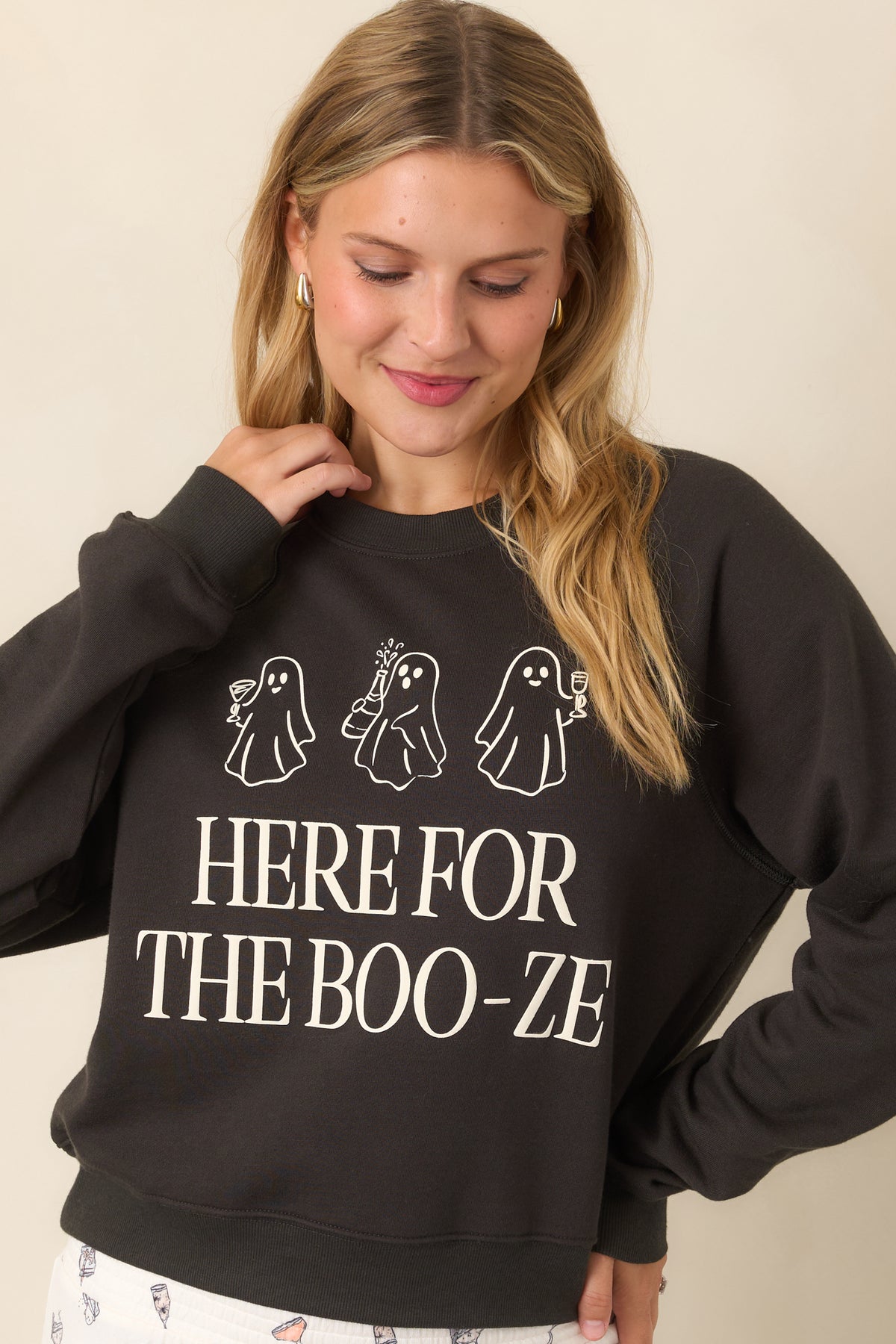 Washed black sweatshirt with oversized “Here for the Boo-ze” text and three cocktail-carrying ghost graphics across the front.