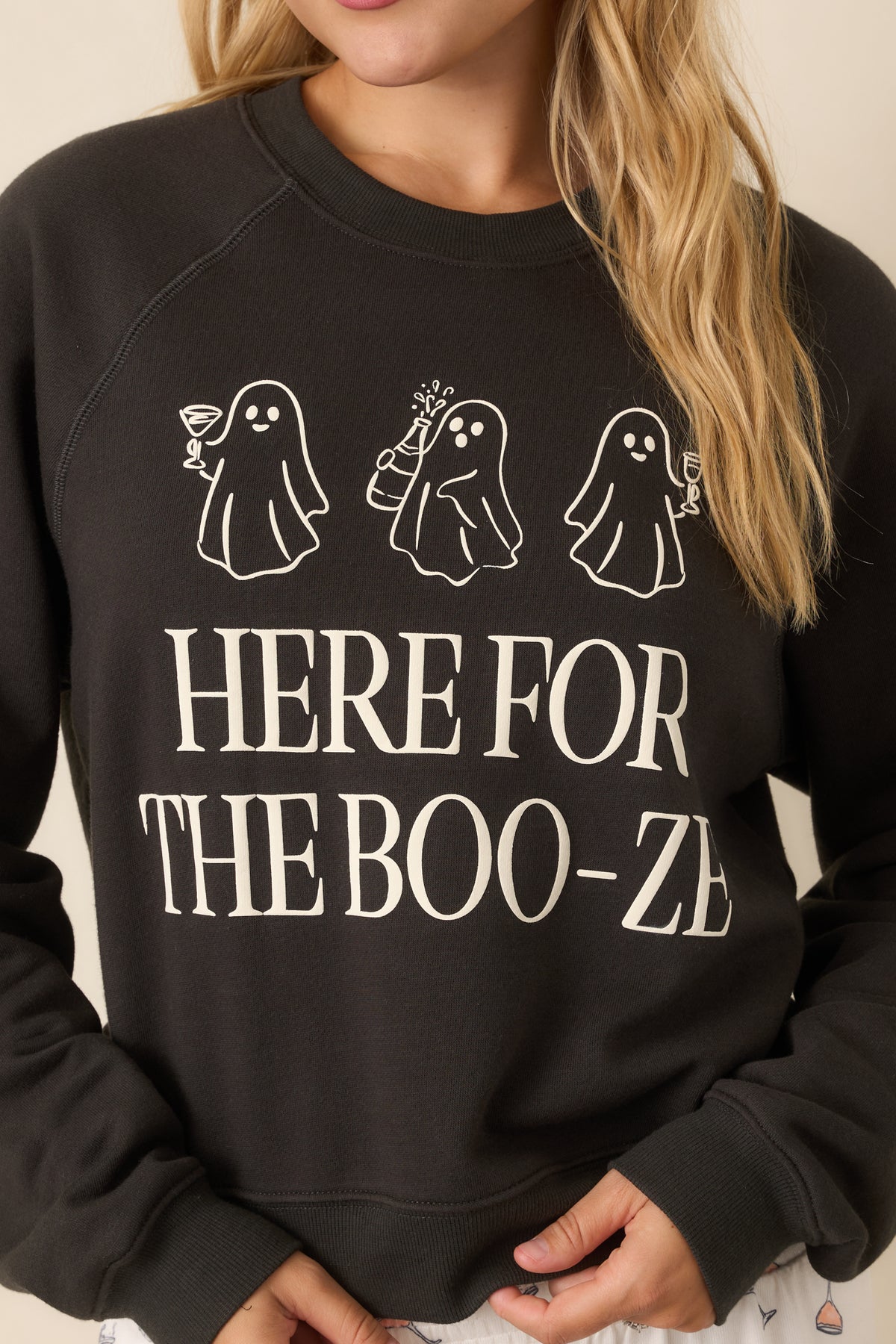 Close-up of the washed black sweatshirt highlighting the three cocktail-carrying ghosts and oversized “Here for the Boo-ze” graphic.