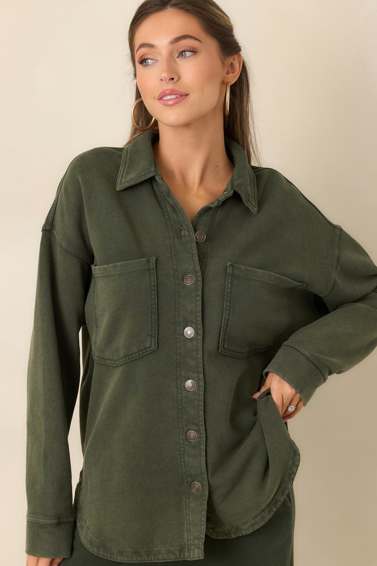 Long sleeves with buttoned cuffs complement the relaxed shape of the washed olive jacket.