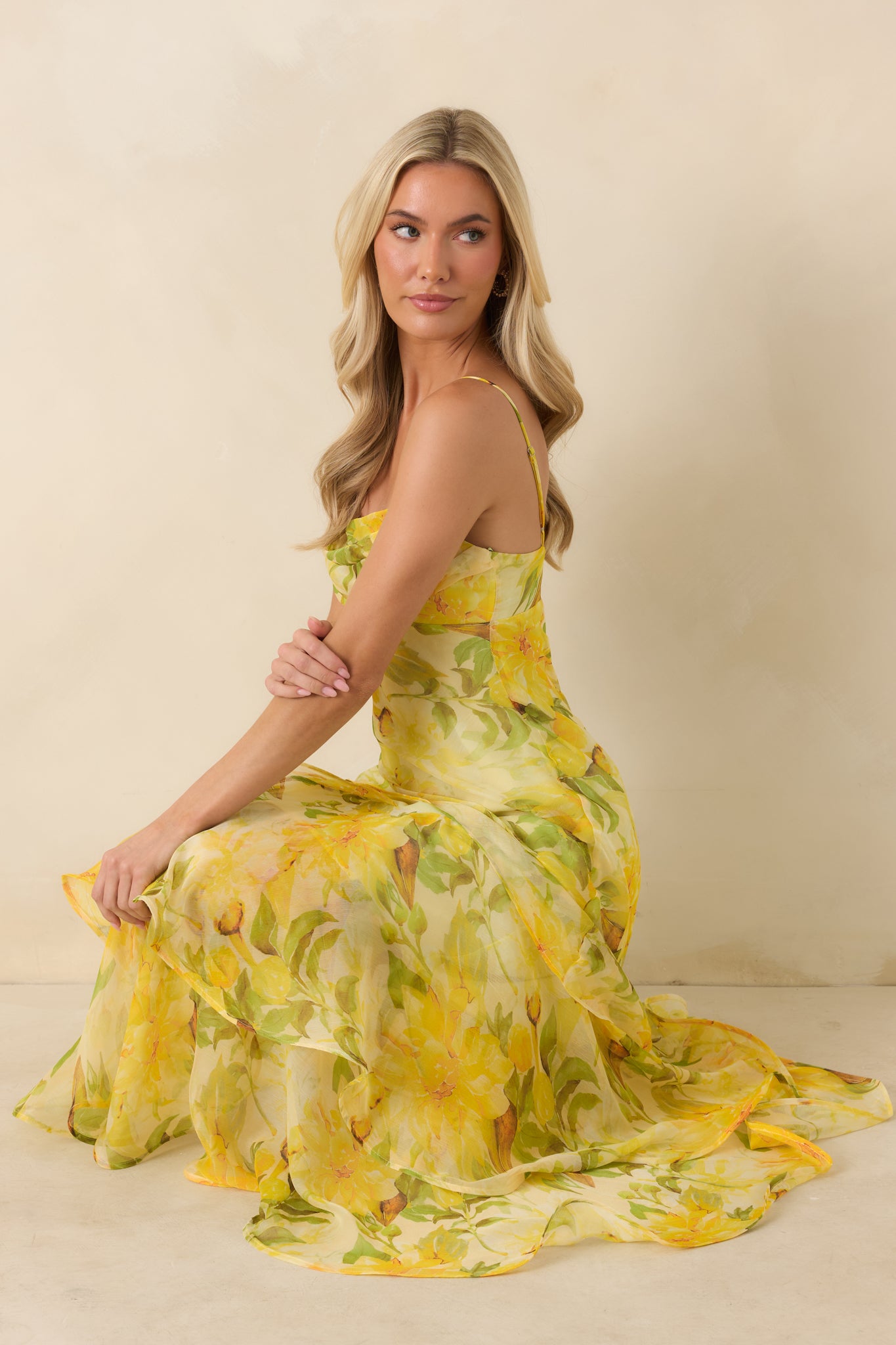 Elegant maxi dress featuring a soft watercolor floral print, fitted bodice, adjustable straps, and a flowing drop-waist silhouette.