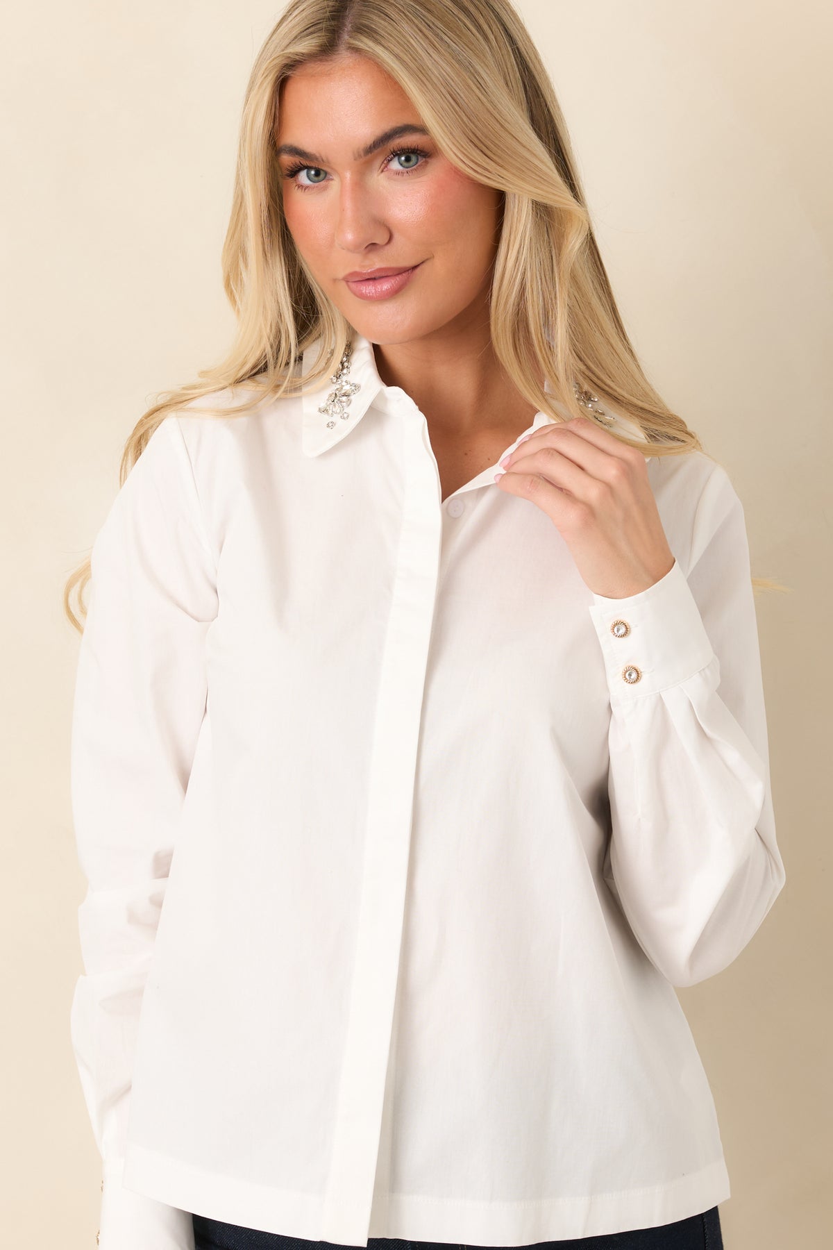 Pointed white collar decorated with faceted jewel accents above the concealed button placket.