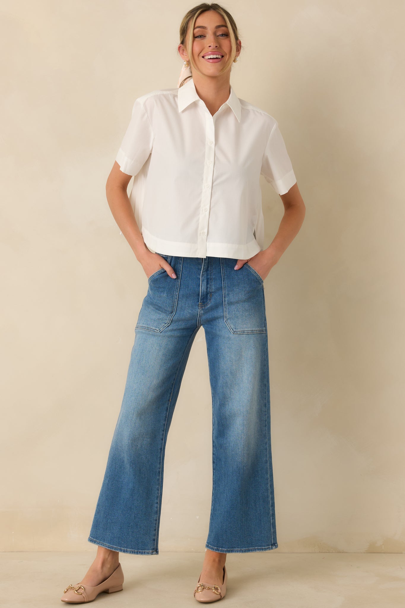 White blouse with smooth structured front, short sleeves, and slightly oversized fit.