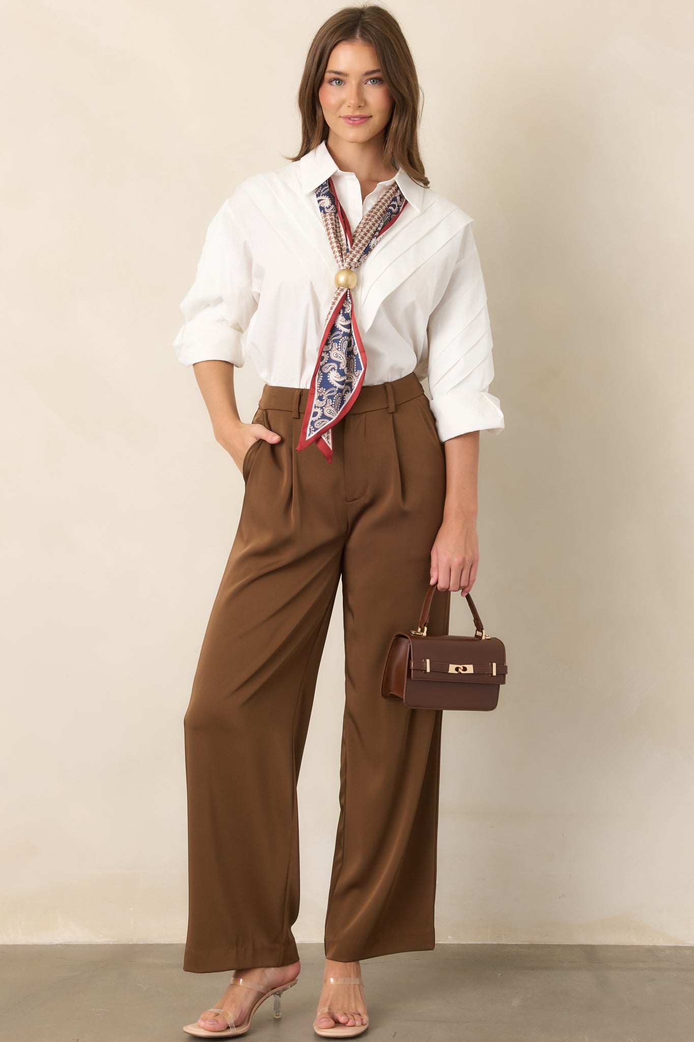 White cotton blouse featuring a classic collar, pleated shoulders, and long button-cuff sleeves.