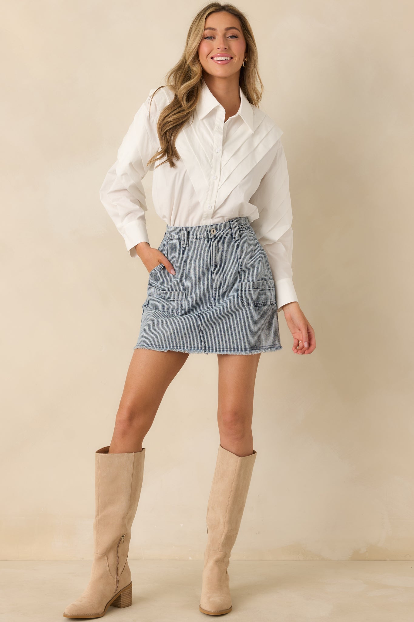 White cotton button-up blouse with a crisp collar, pleated shoulder detailing, and a structured woven finish.