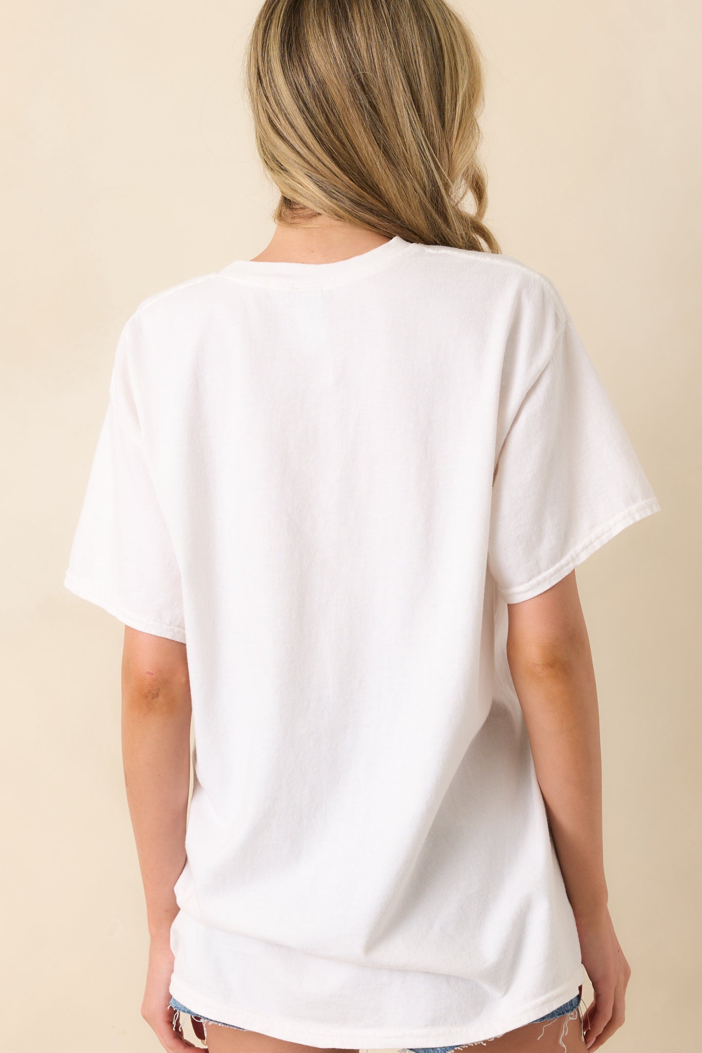 Rear view of the white tee displaying the plain back, short sleeves, and easy fit across the shoulders and hem.