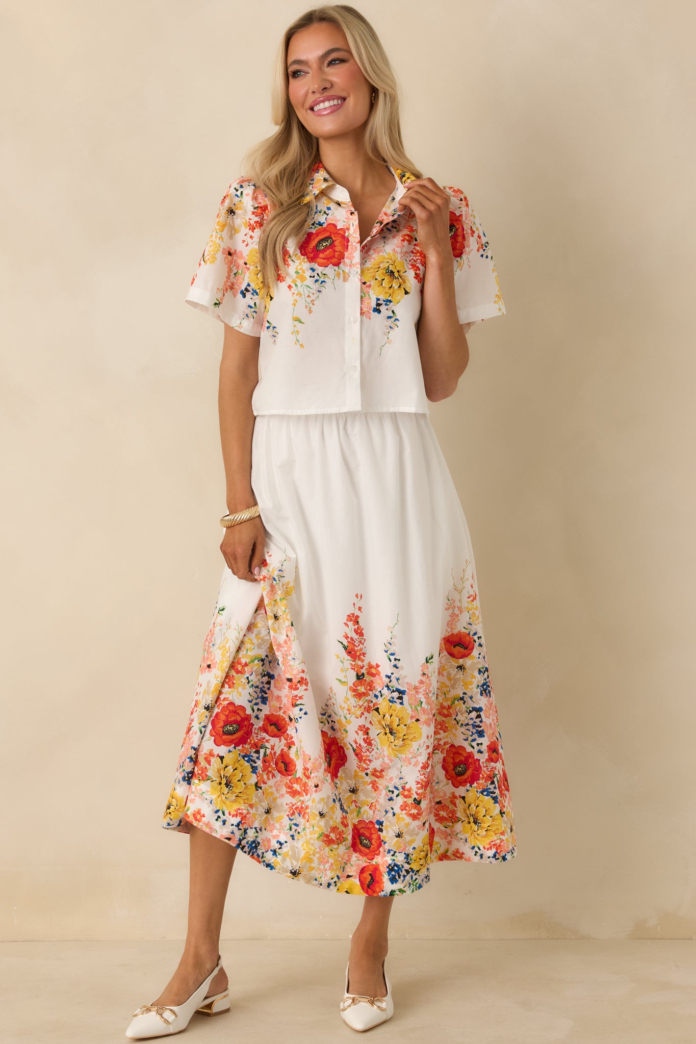 White cotton maxi skirt designed with a comfortable high-rise fit, airy movement, and floral print detailing at the hem.
