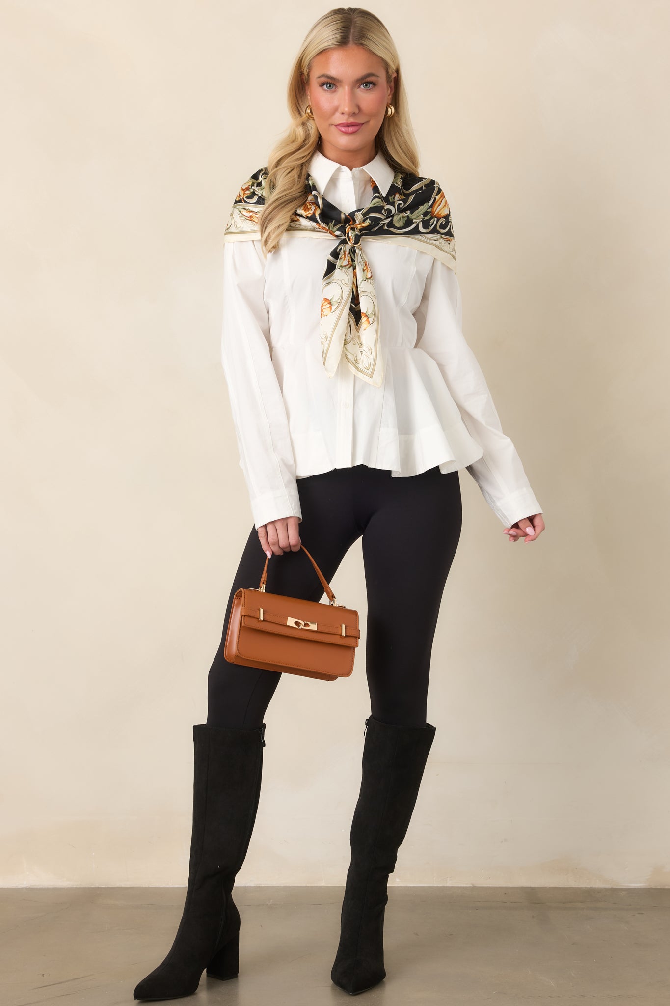 White cotton peplum top featuring a classic collar, long sleeves, full button front, and defined waist.