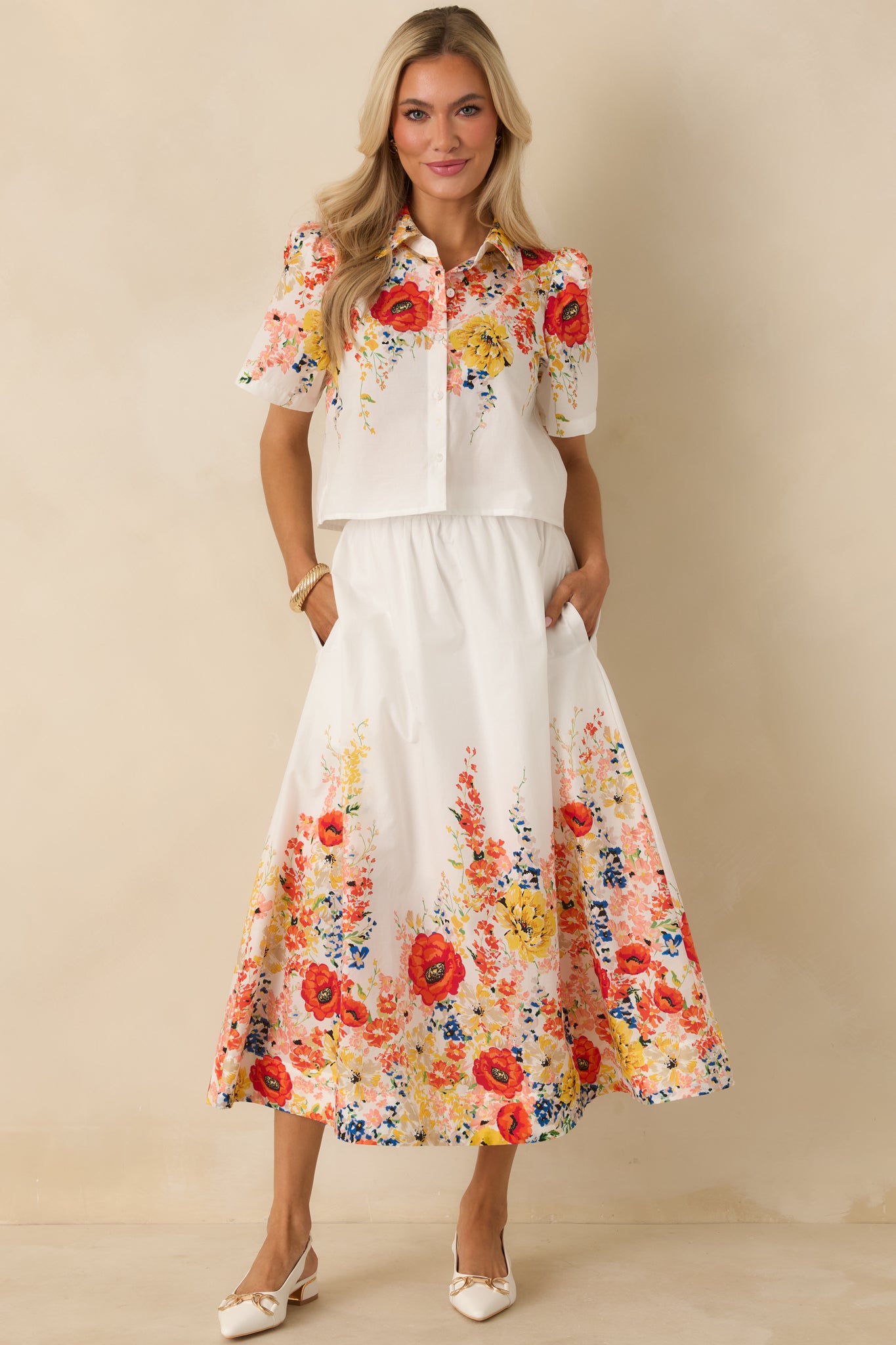 White cotton short sleeve top featuring a relaxed silhouette, button-down front, structured collar, and allover multicolor floral print.