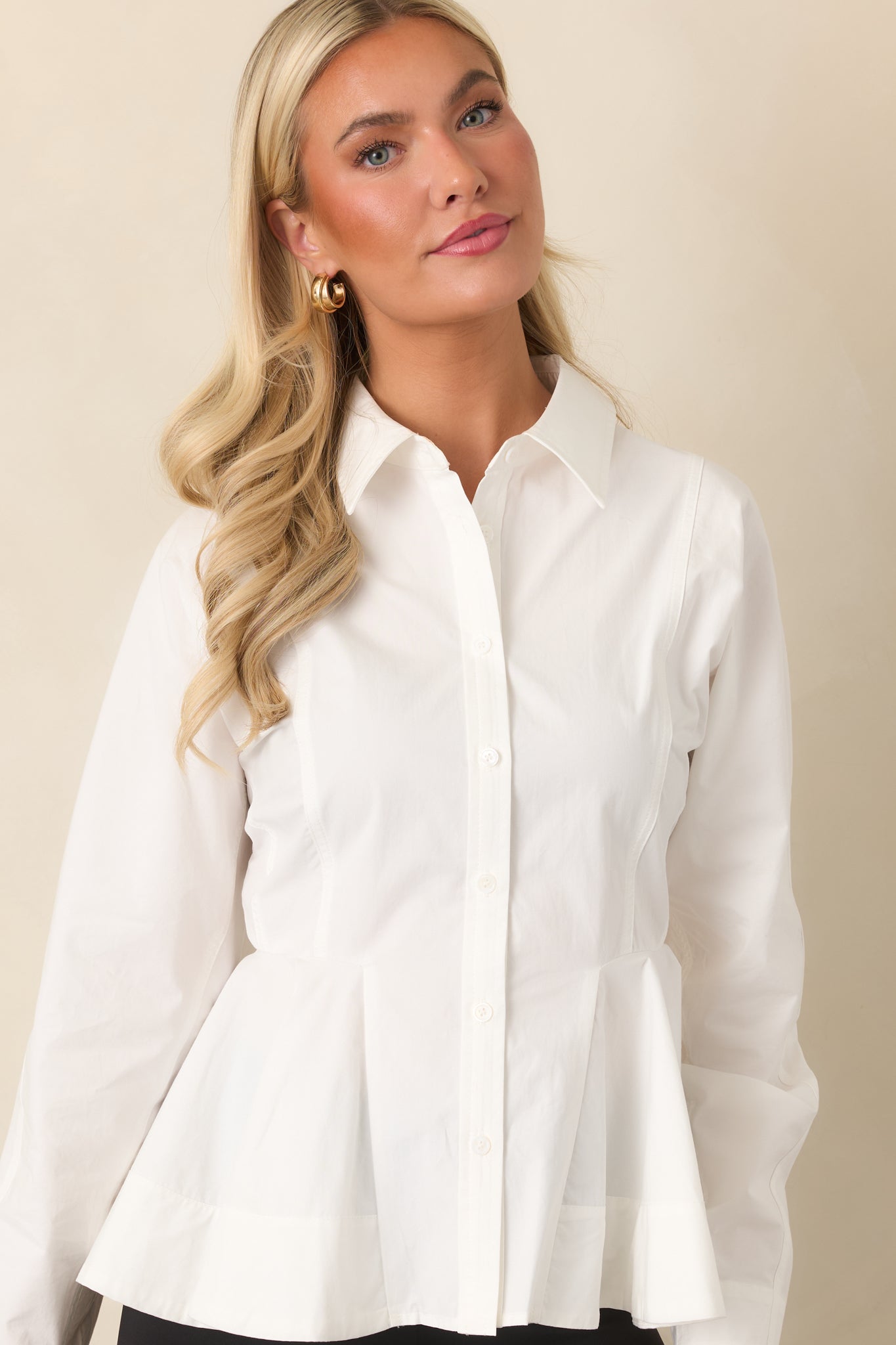 White cotton top highlighting the collared neckline, front buttons, and waist-defining seam details.