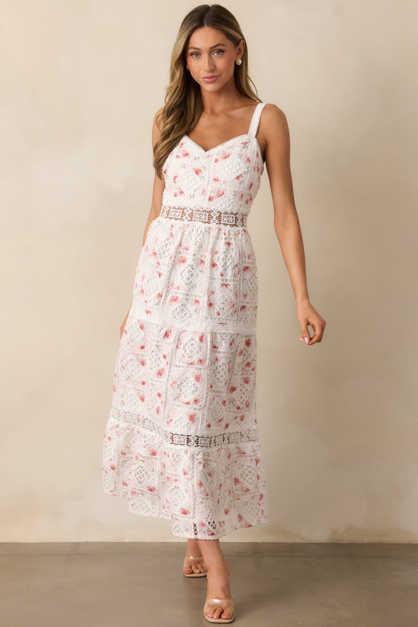 A chic white dress with embroidered eyelet detailing, a flattering ladder trim waist, and a tiered silhouette.
