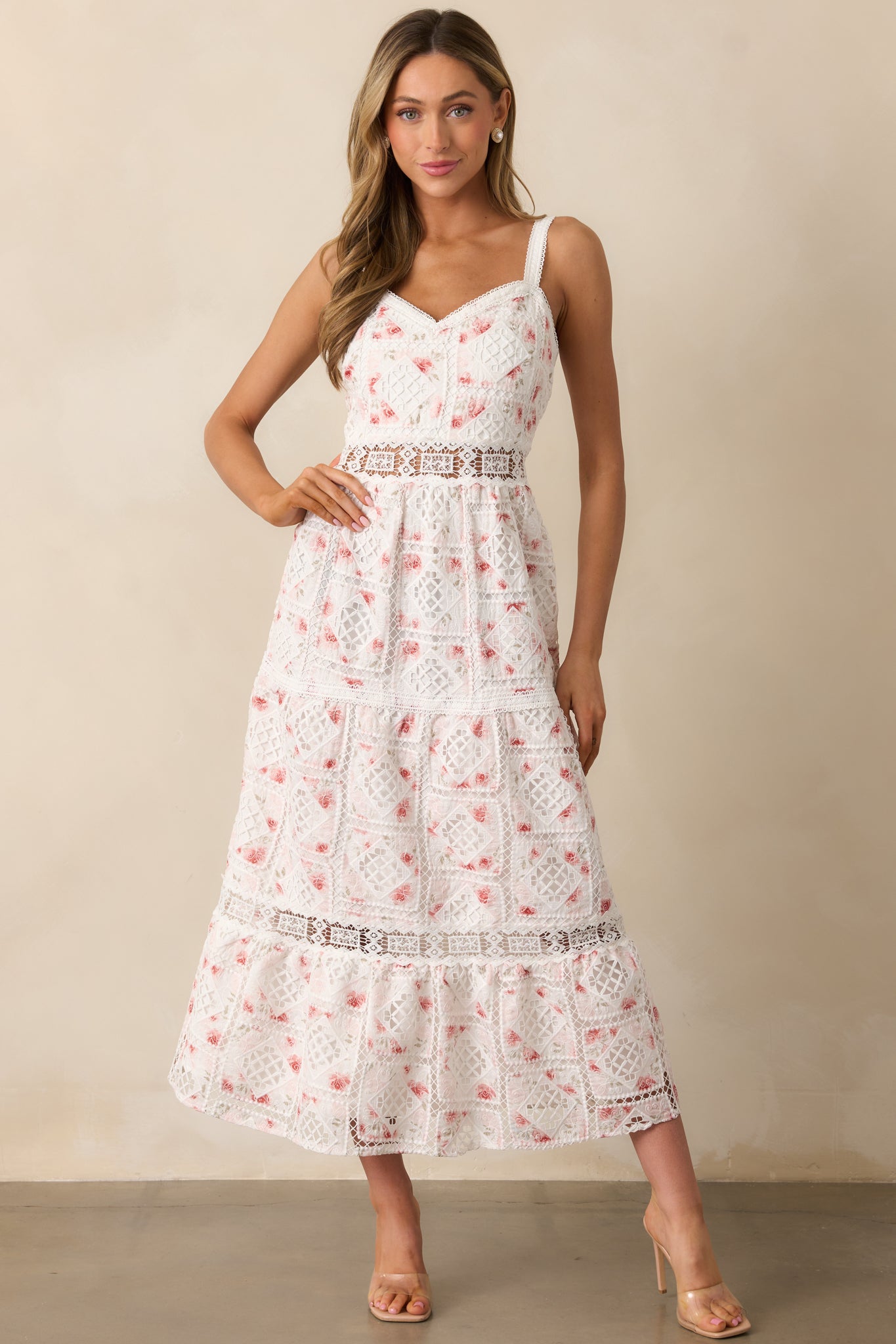 A white dress featuring a V-neck neckline, intricate eyelet detailing, and an embroidered overlay for a delicate look.