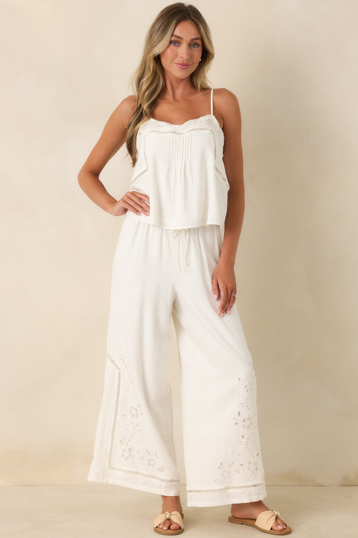 White embroidered camisole top featuring a square neckline with lace trim, floral embroidery, pintuck detailing, and adjustable spaghetti straps.