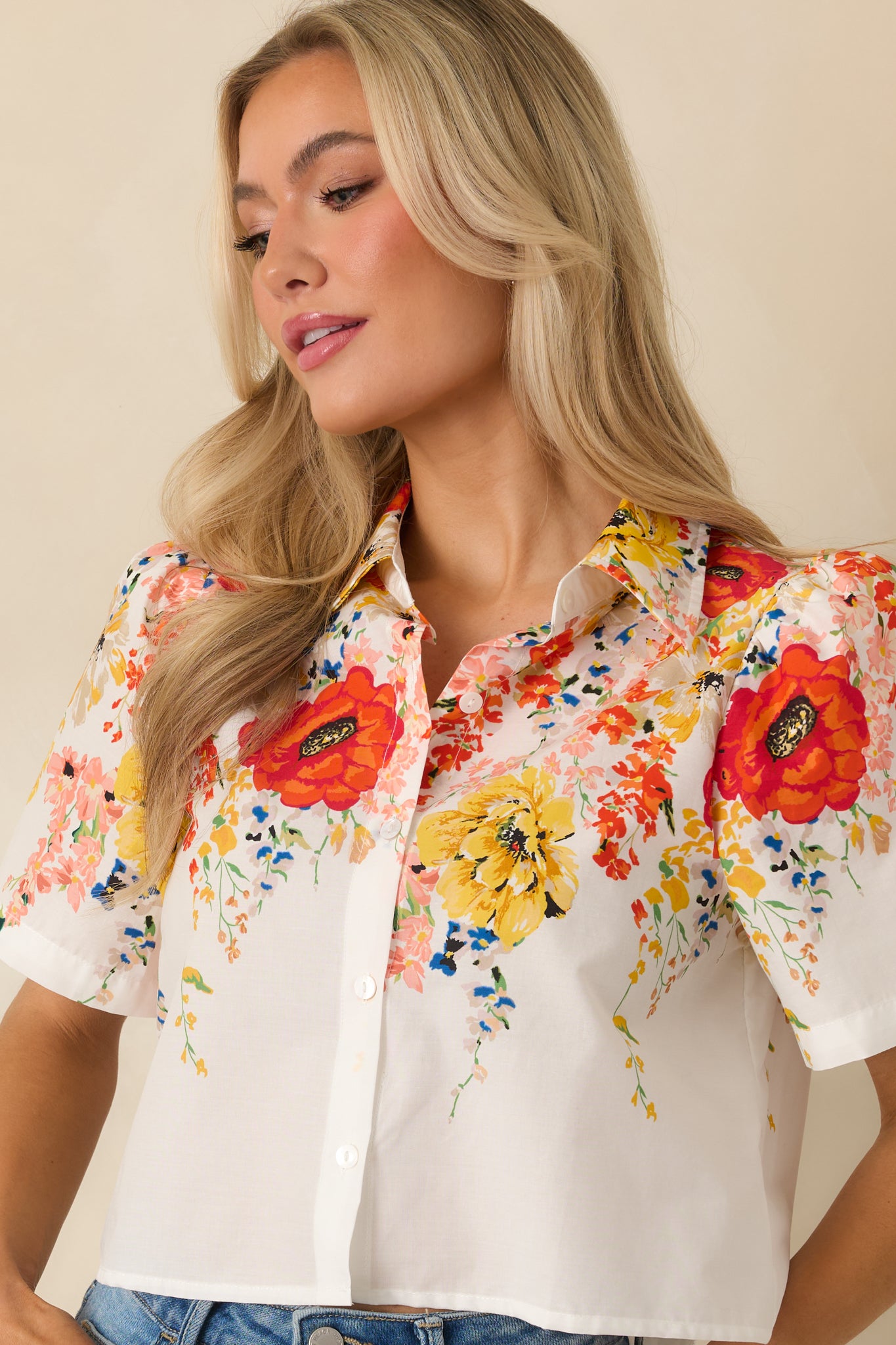 White floral cotton top highlighting the button placket, collared neckline, and lightweight breathable fabric.