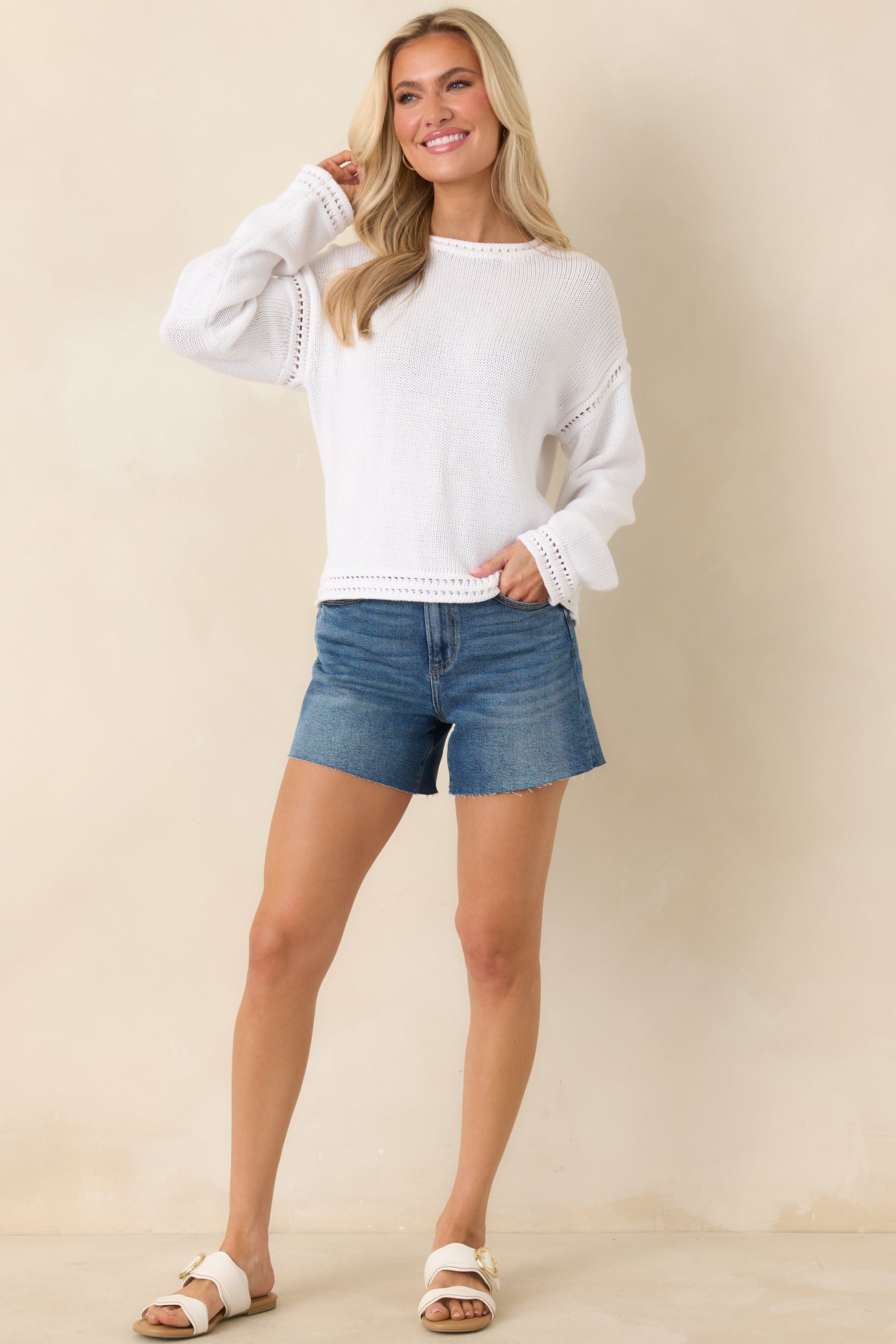 Classic white knit pullover featuring textured open-stitch accents on the sleeves and a structured ribbed trim finish.