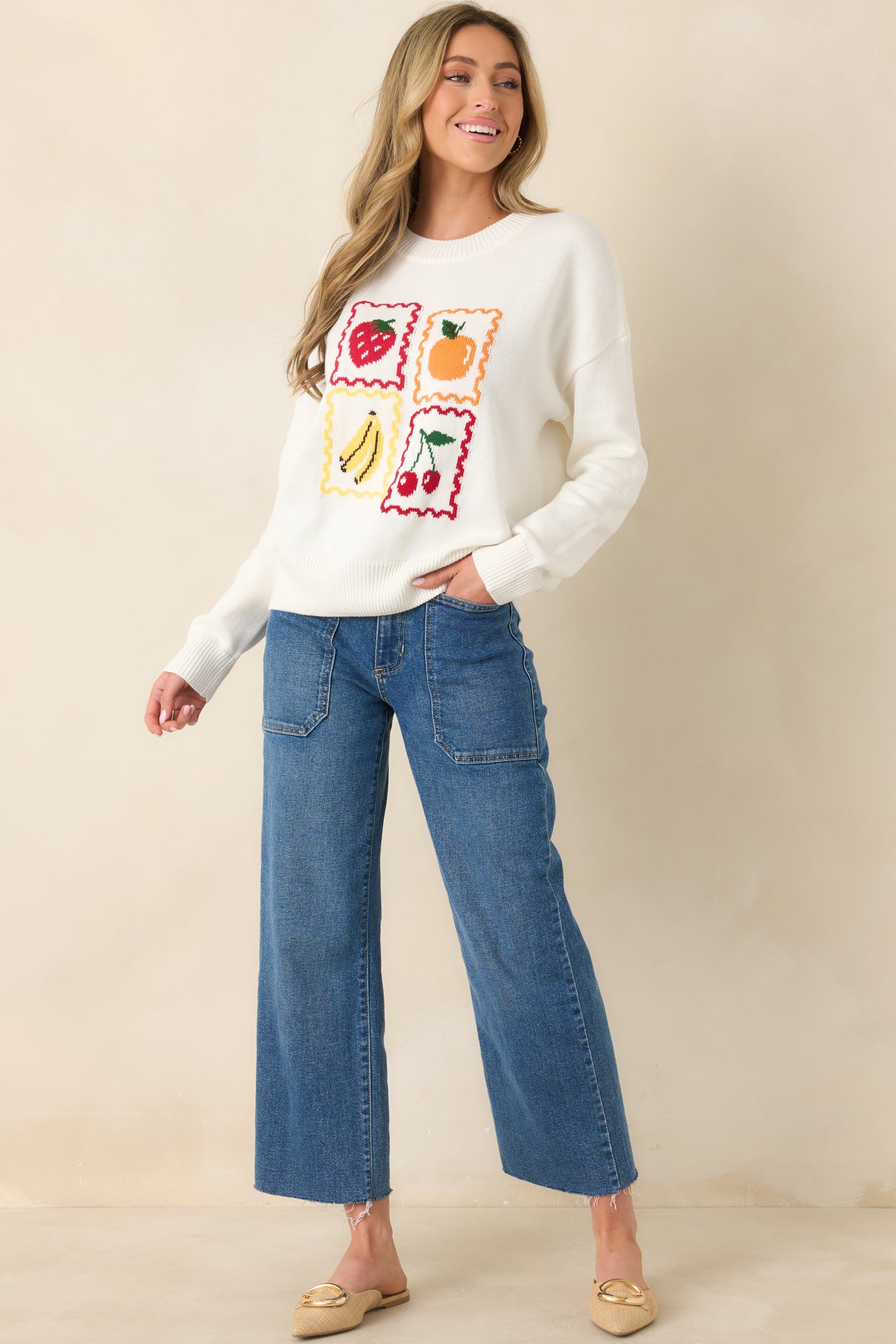 White knit pullover with colorful fruit stamp graphics and relaxed fit.