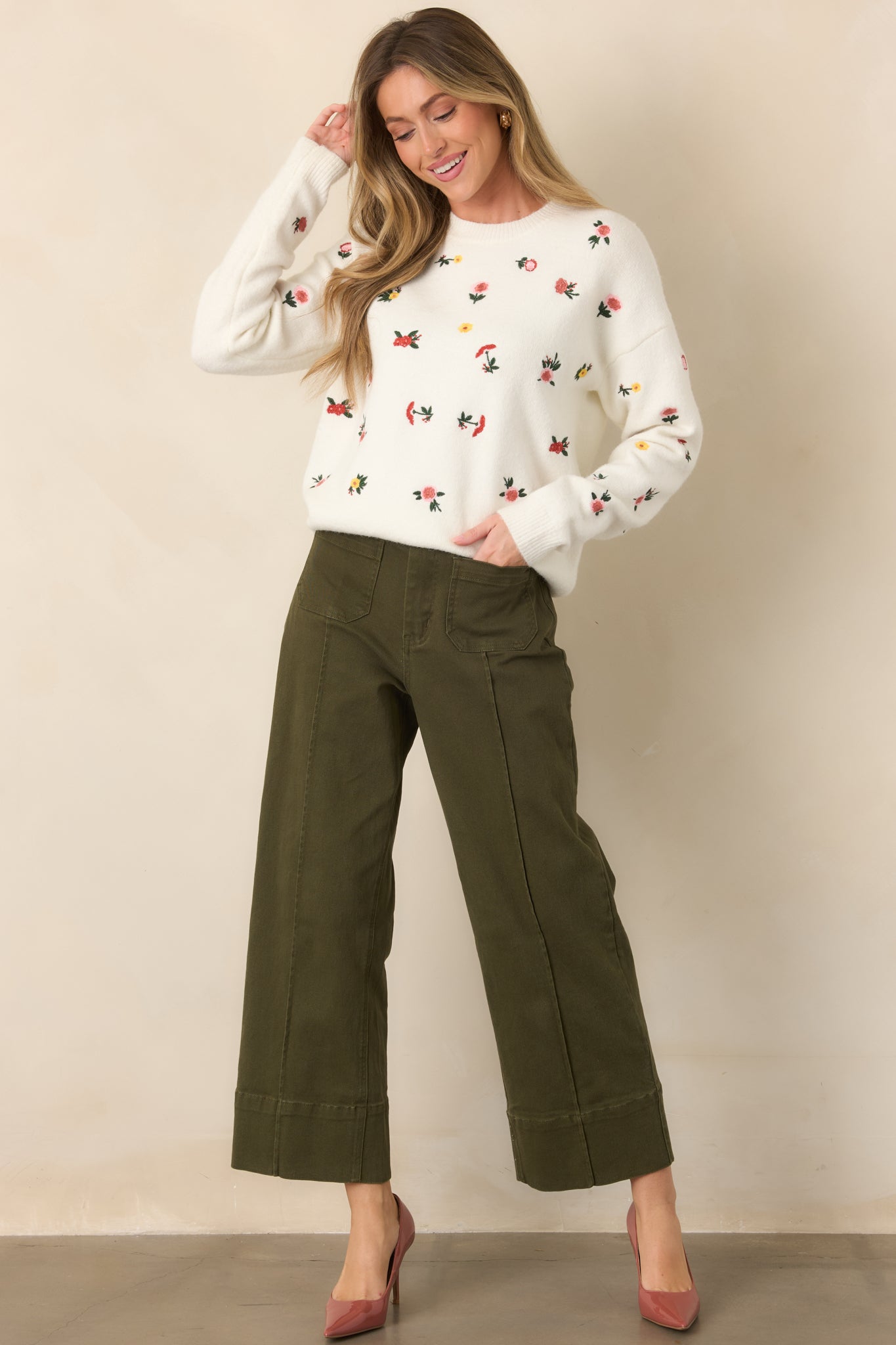 White knit sweater featuring multicolor floral embroidery throughout, a classic crew neckline, long sleeves, and ribbed trim.