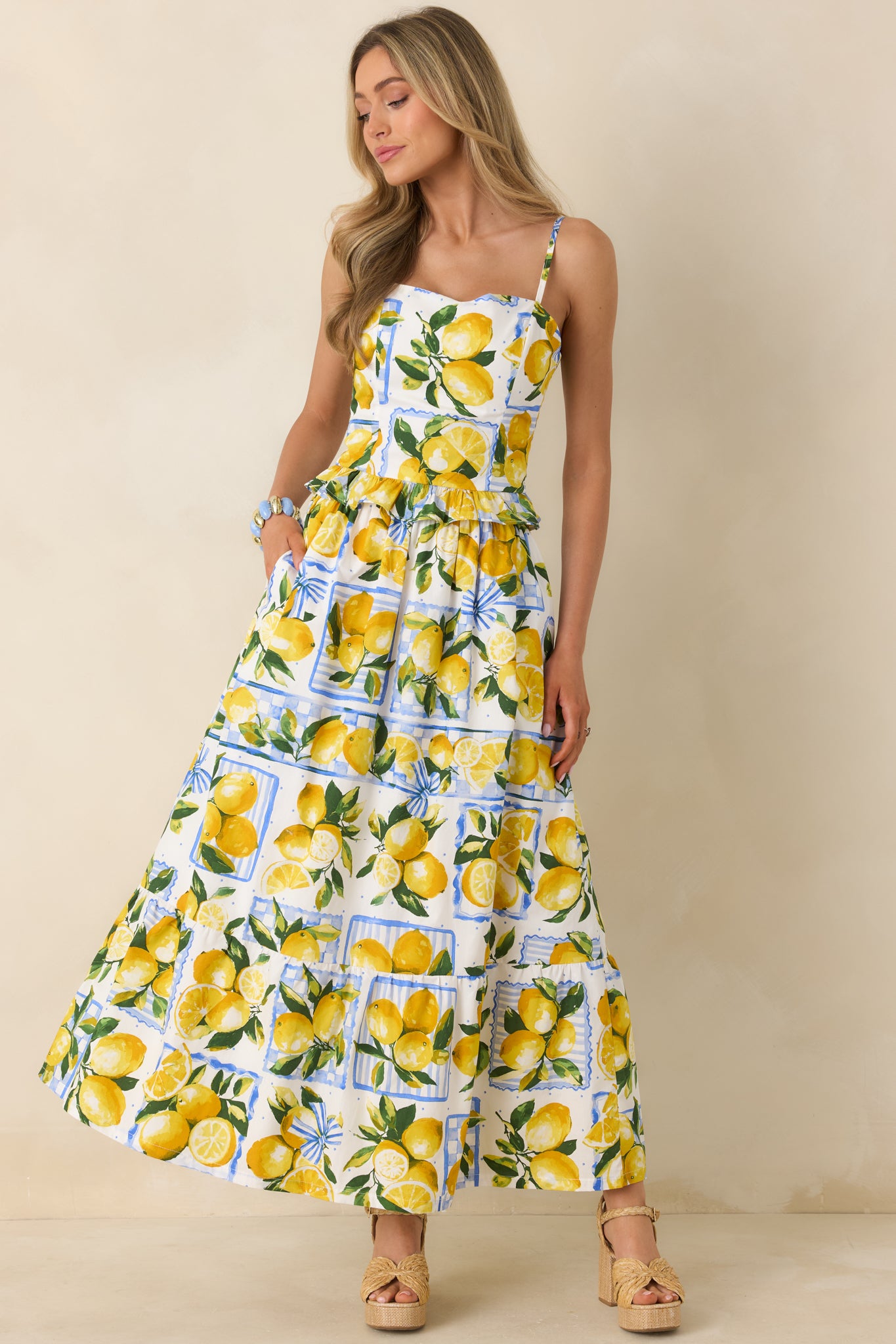 White lemon print peplum top in lightweight cotton featuring adjustable spaghetti straps and a softly flared ruffle hem.