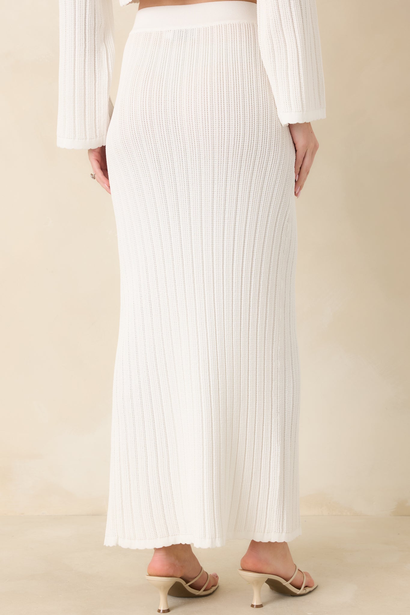 White midi skirt displaying a smooth rear silhouette with elastic waistband and clean straight drape.