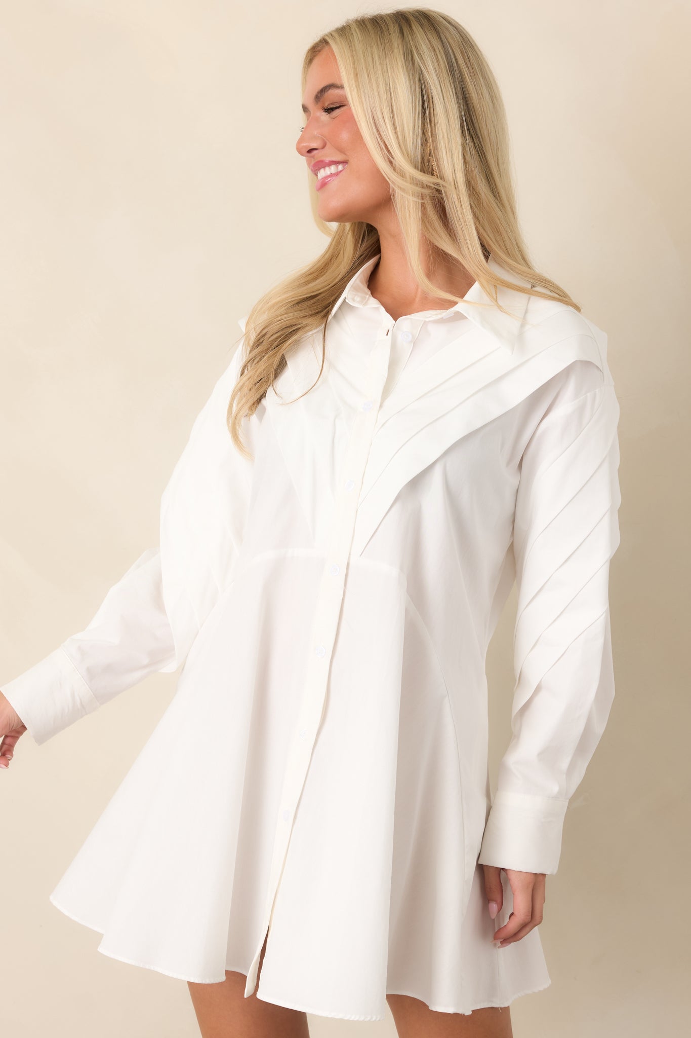 Close view of the long sleeve featuring a button cuff and softly structured pleated shoulder detail.