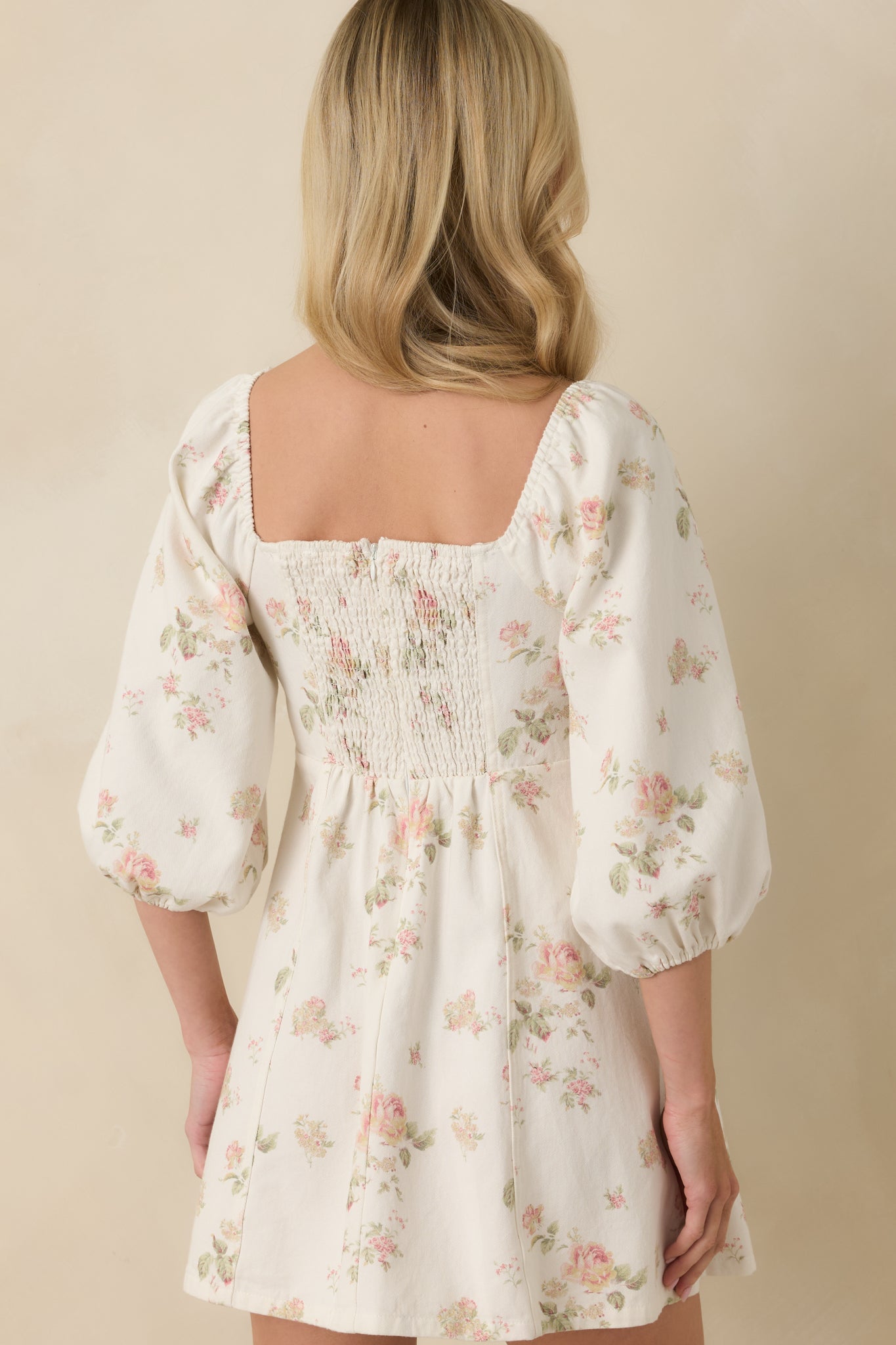 White multi floral mini dress with a smocked rear panel and softly flared skirt.