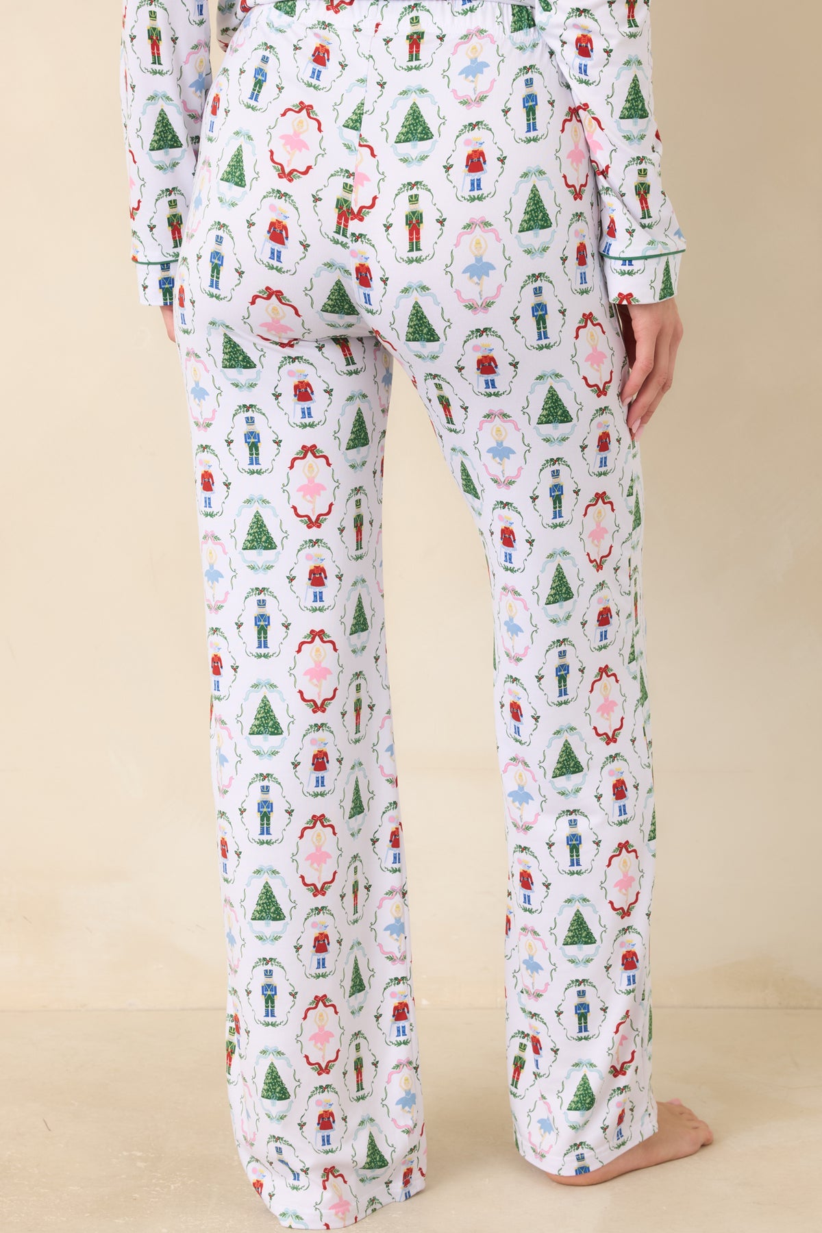 Rear of the white pajama pants showcases the allover nutcracker and holiday motif print with a relaxed wide-leg silhouette.