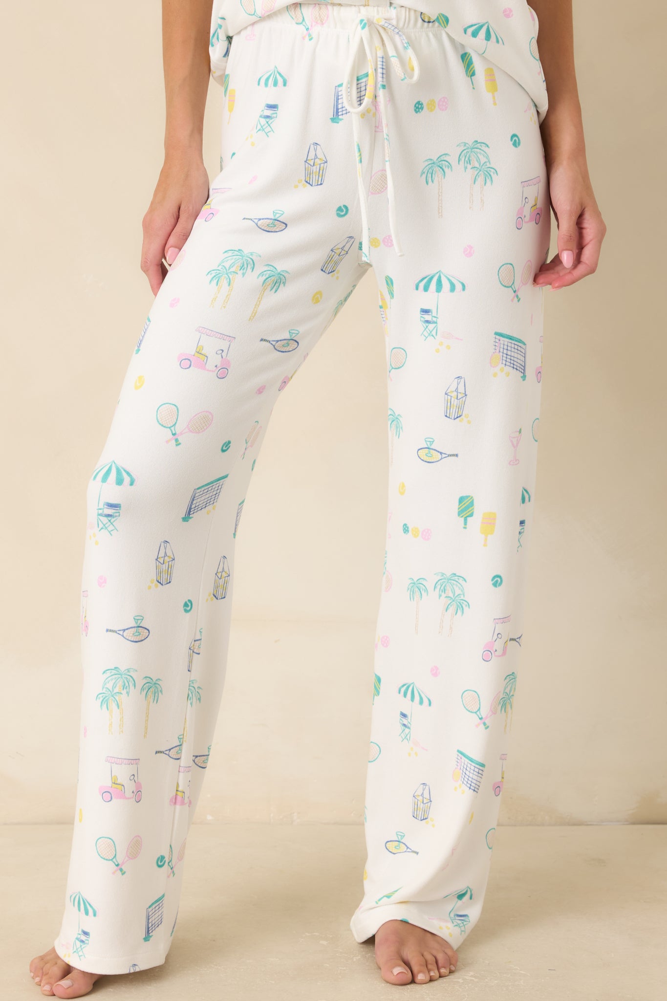 Close view of the white pajama pants highlighting the elastic waistband, adjustable drawstring tie, and colorful print details.