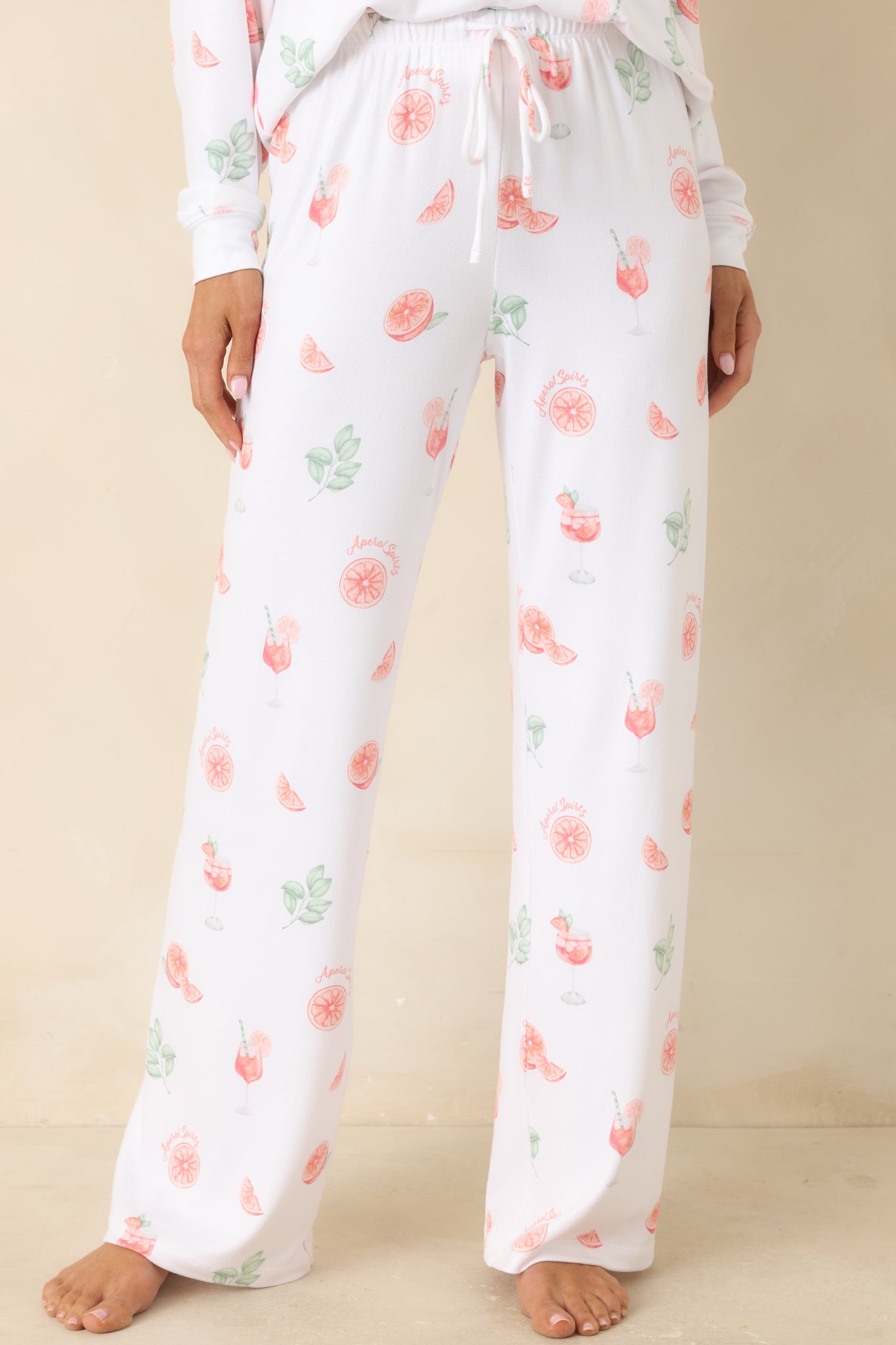 White pajama pants with citrus print, highlighting the elastic waistband and drawstring detail.