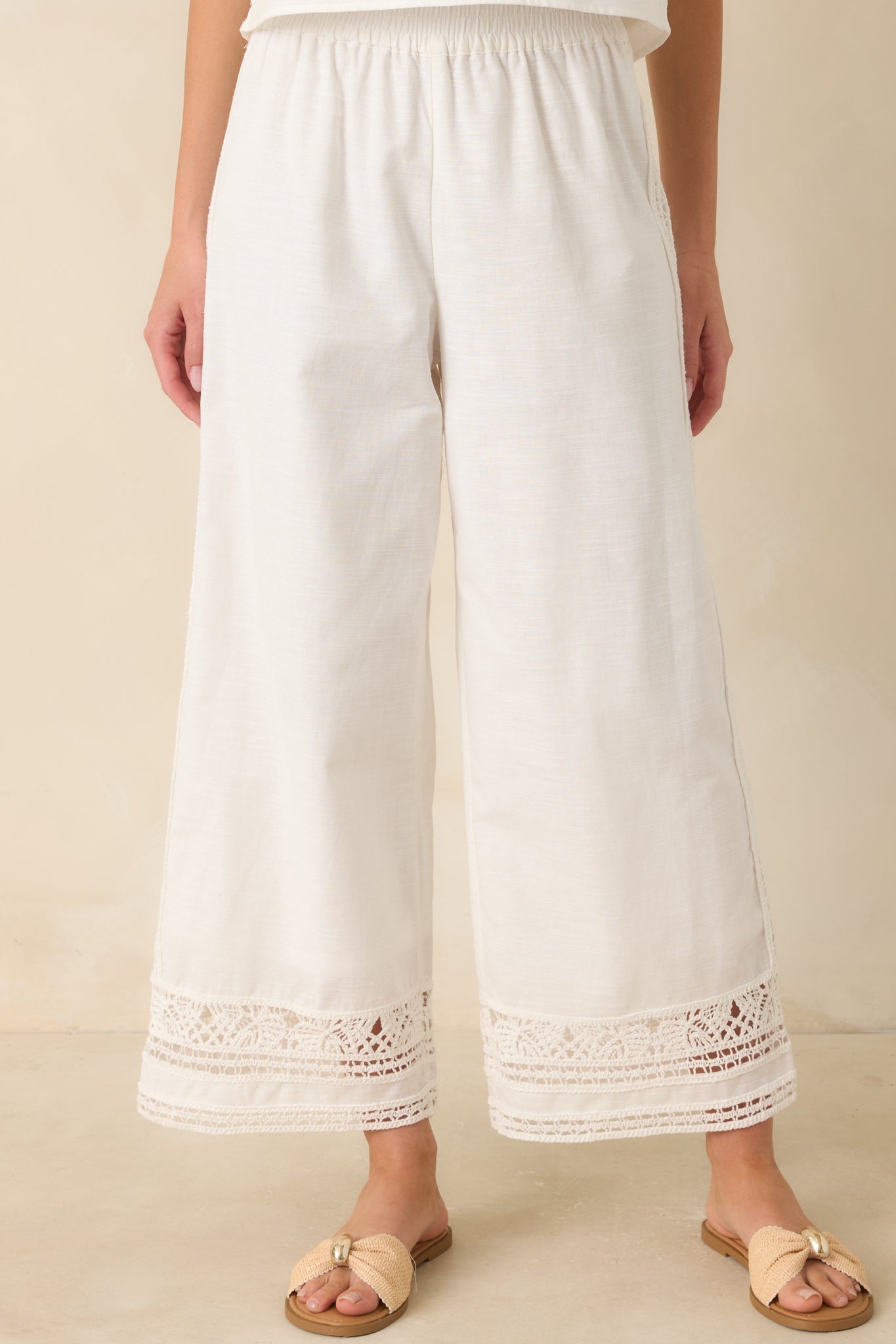 Close view of the elastic waistband highlighting the soft stretch construction of the white pants.