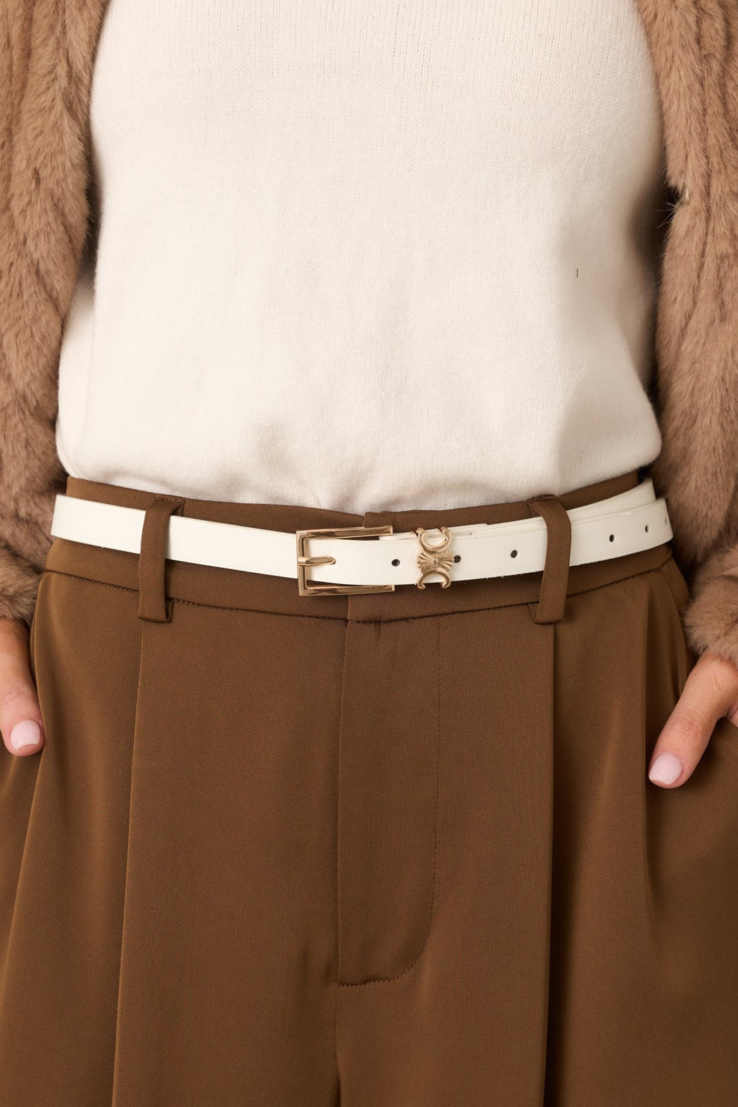 Close-up of white slim belt highlighting gold-tone buckle, faux leather texture, and adjustable strap.