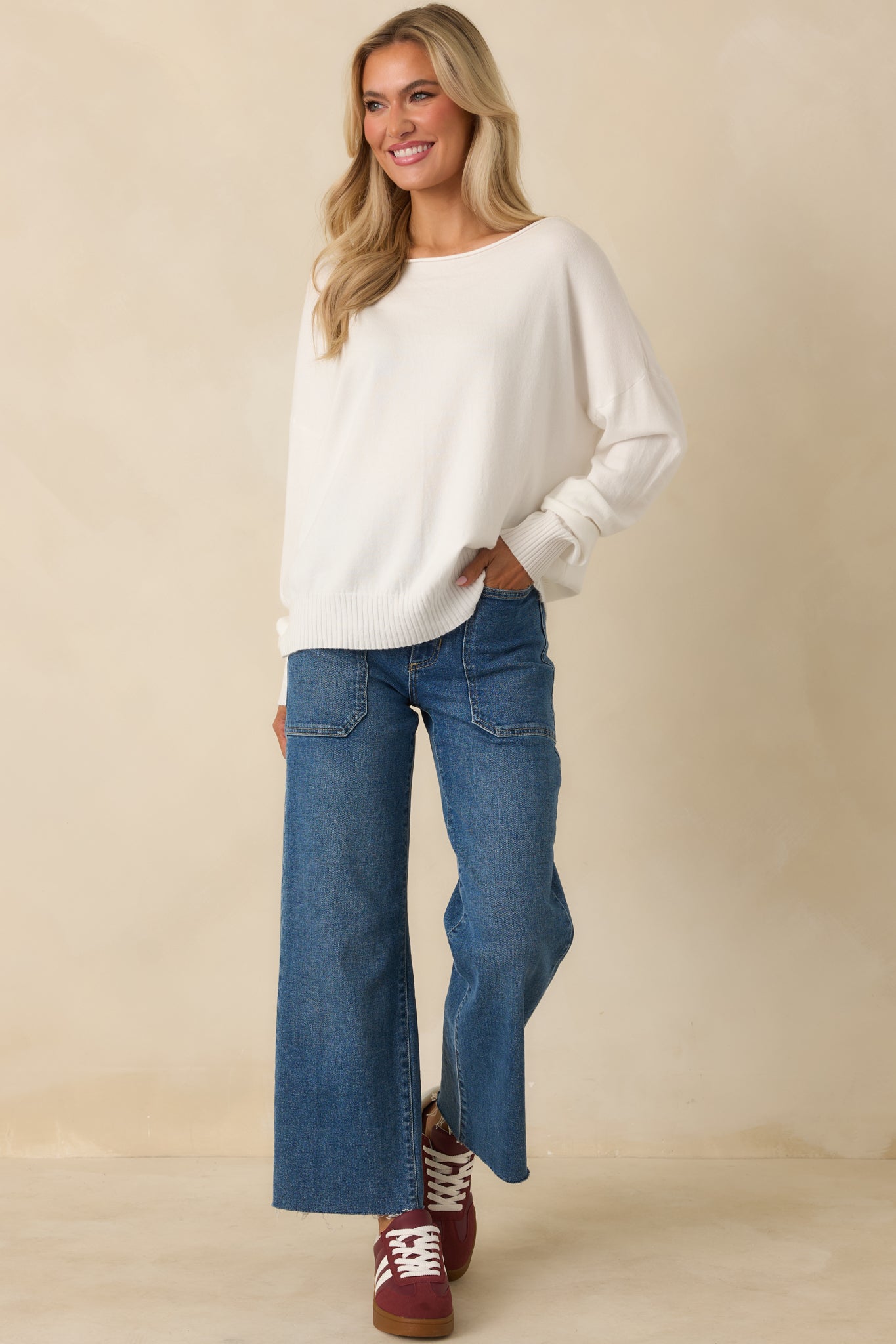 Front-facing angle of white sweater highlighting lightweight knit fabric and gently draped silhouette.